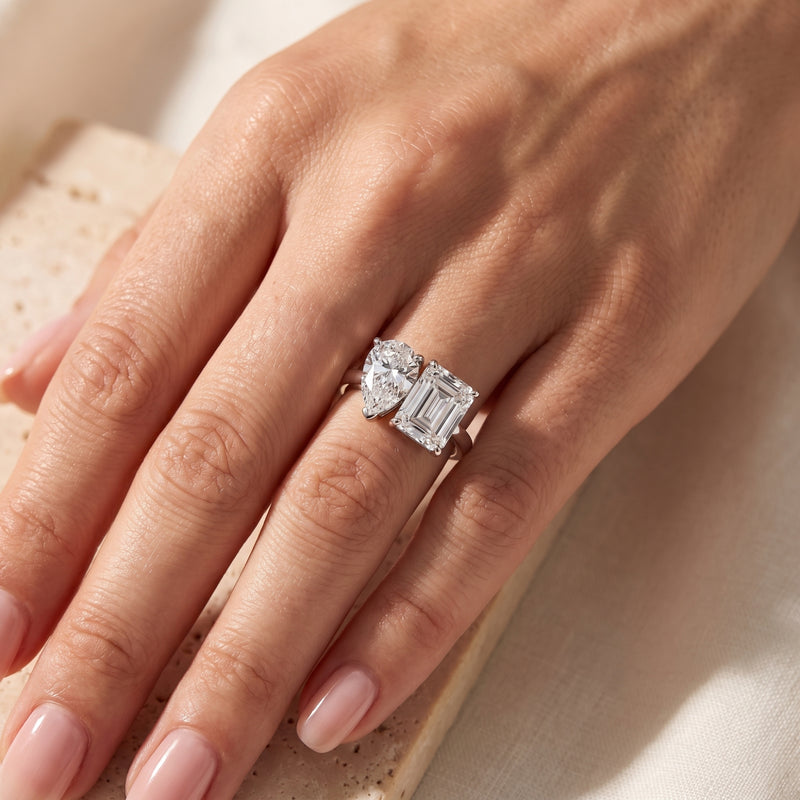 The Georgina Duo silver bypass ring featuring pear and emerald cut simulated diamonds worn on a woman's finger.