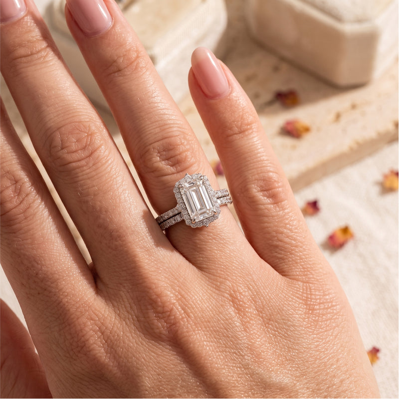 Sterling silver emerald-cut halo ring set worn on a finger with a lifestyle background.