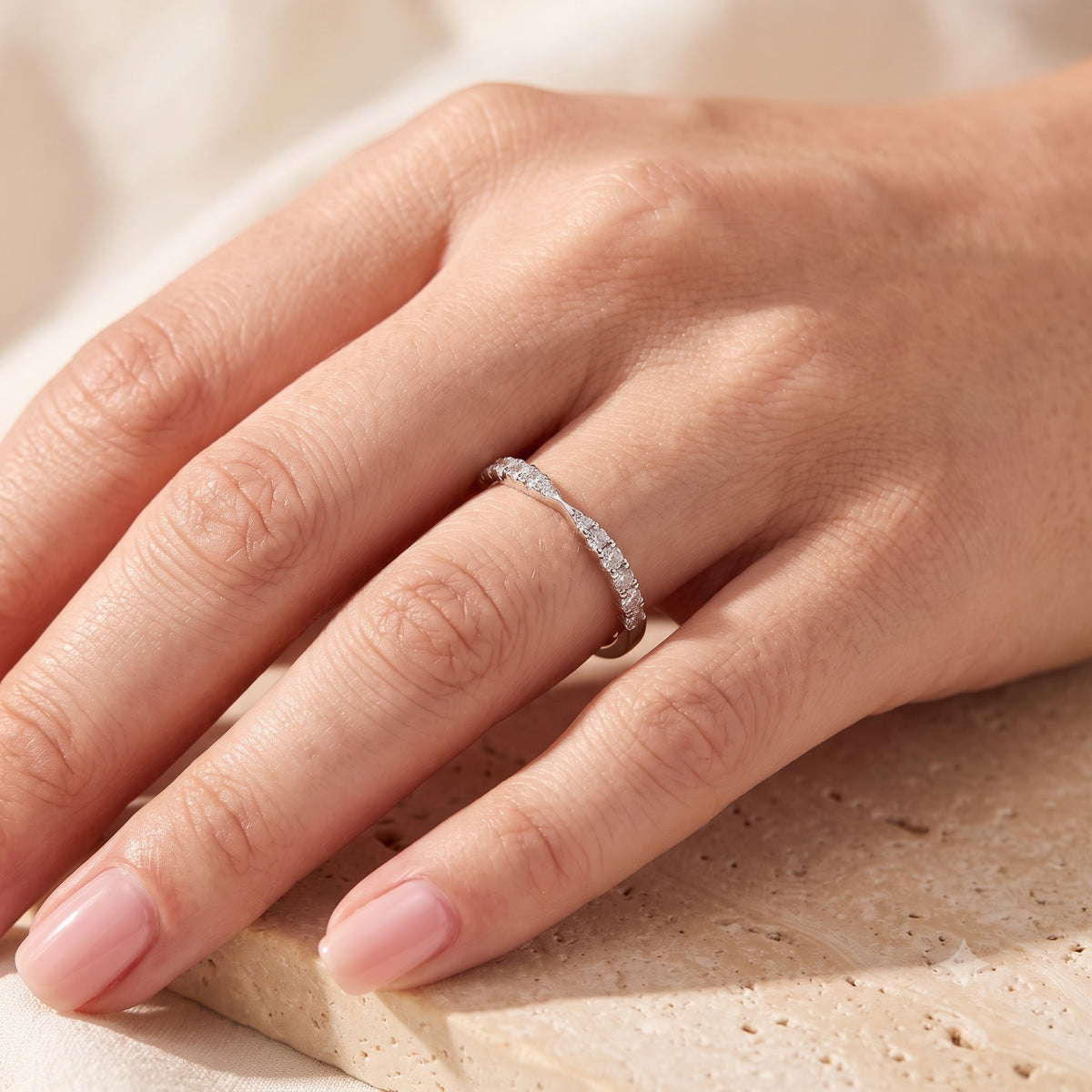 The Fleuriana S925 sterling silver wave ring with simulated diamonds worn on a woman's hand.