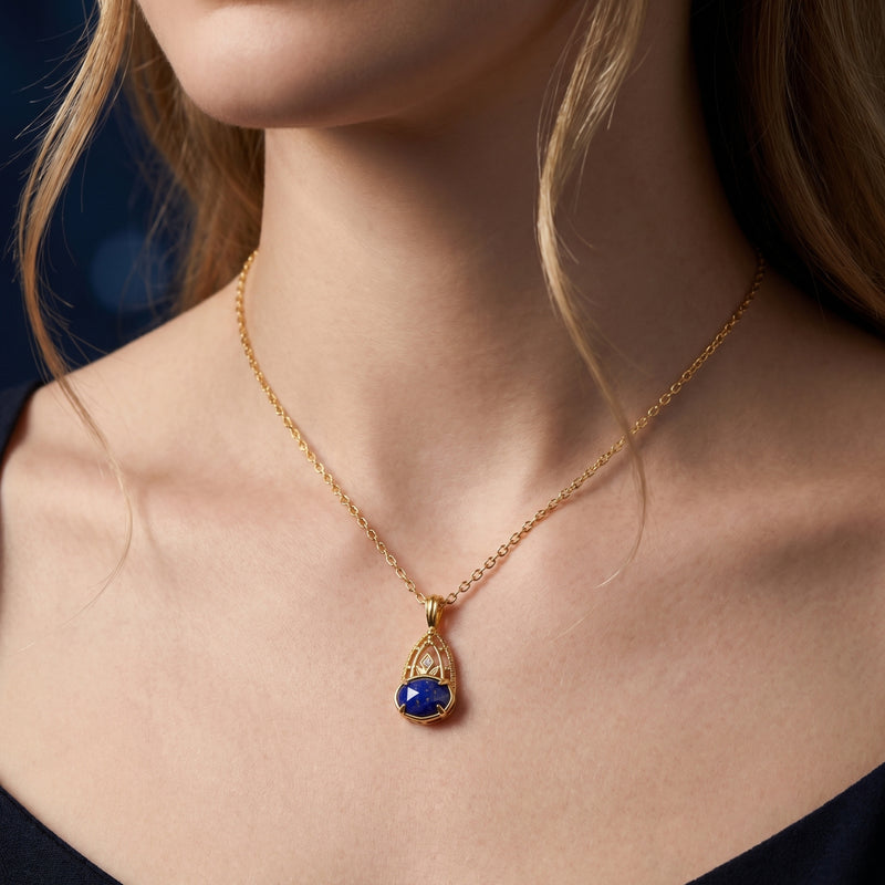 Model wearing the yellow gold Azure Crest necklace featuring a blue oval lapis lazuli pendant.