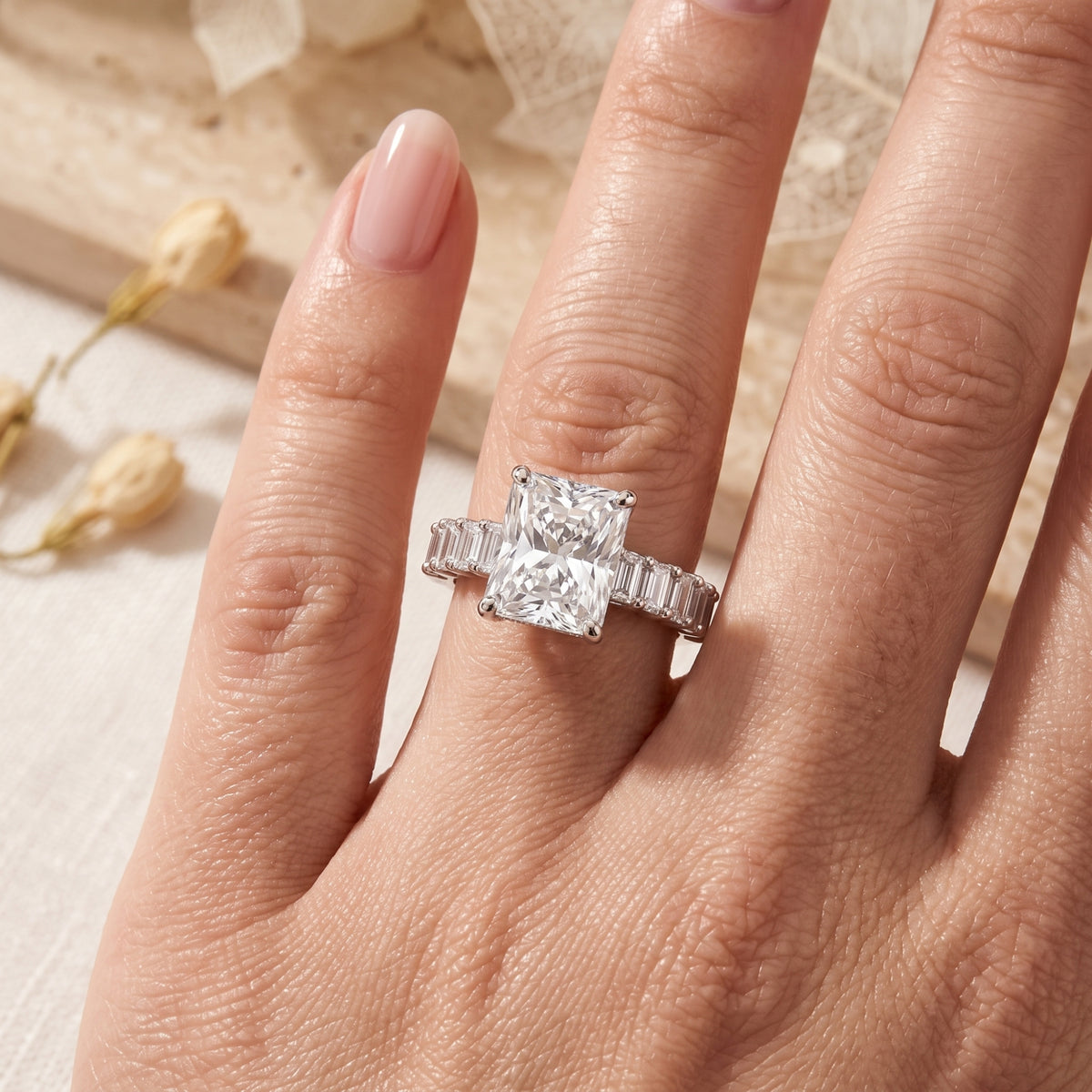 Top view of the sterling silver radiant cut simulated diamond ring worn on a woman's hand.