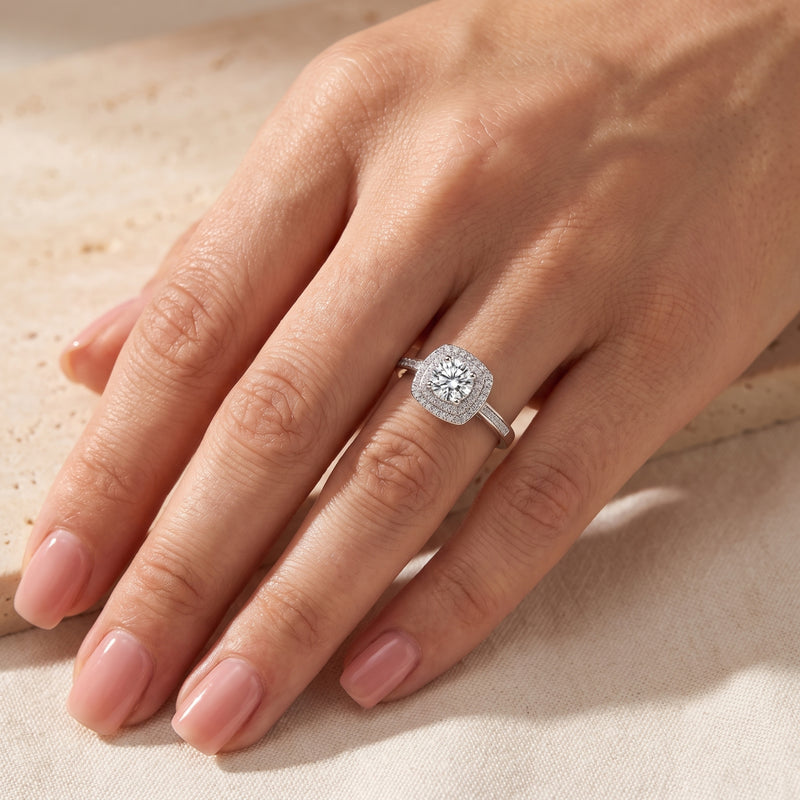 Round cut simulated diamond Juliette ring in sterling silver worn on a model's hand.