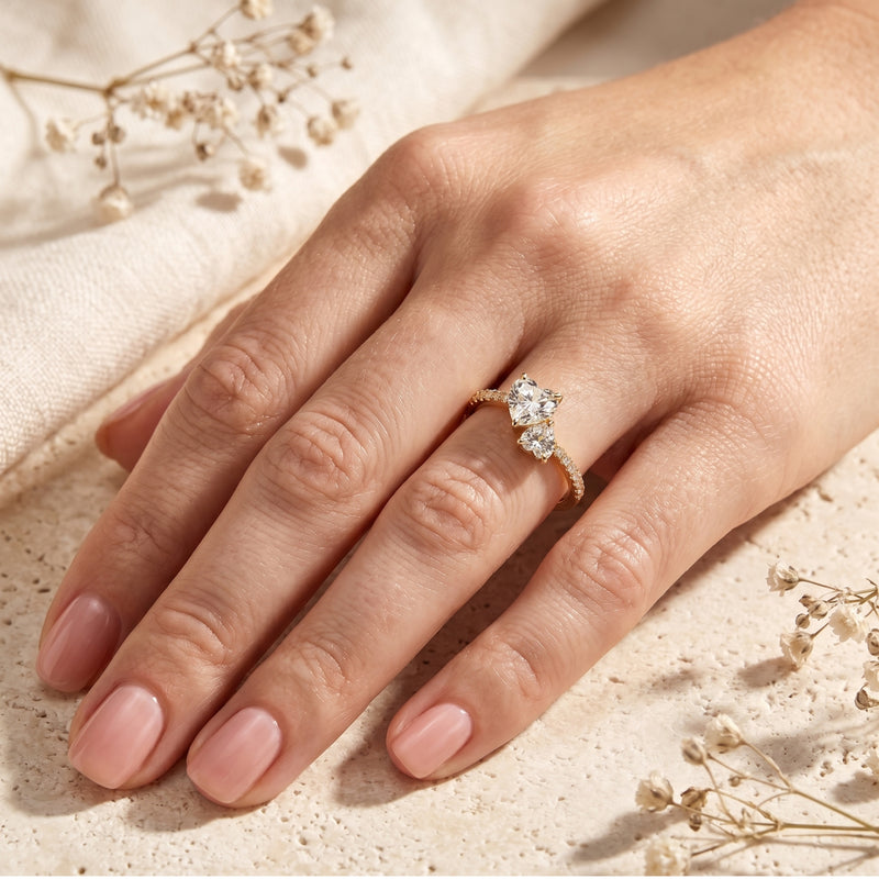 Gold-plated heart-cut moissanite bypass ring worn on a woman's hand.