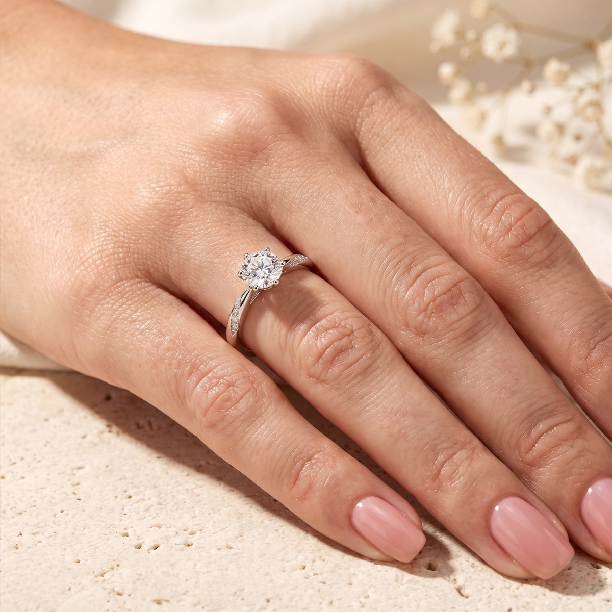 Close-up of the silver-tone twist ring worn on a hand's ring finger.
