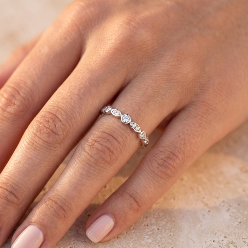 Sterling silver cubic zirconia eternity band worn on a model's hand.