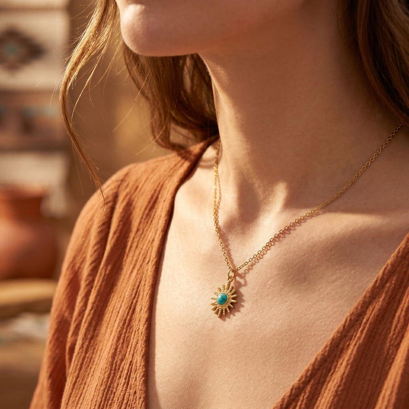 Model wearing the 18K gold sunburst turquoise necklace, styled with a terracotta top for a bohemian look.