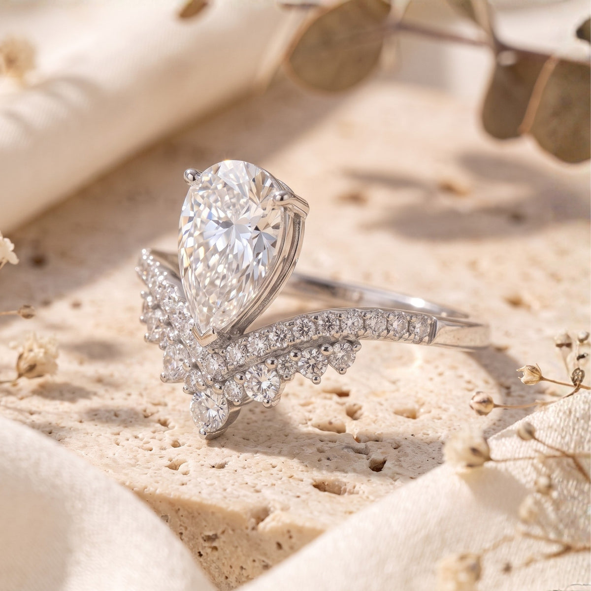 Side profile of sterling silver pear-cut simulated diamond wishbone ring on stone.