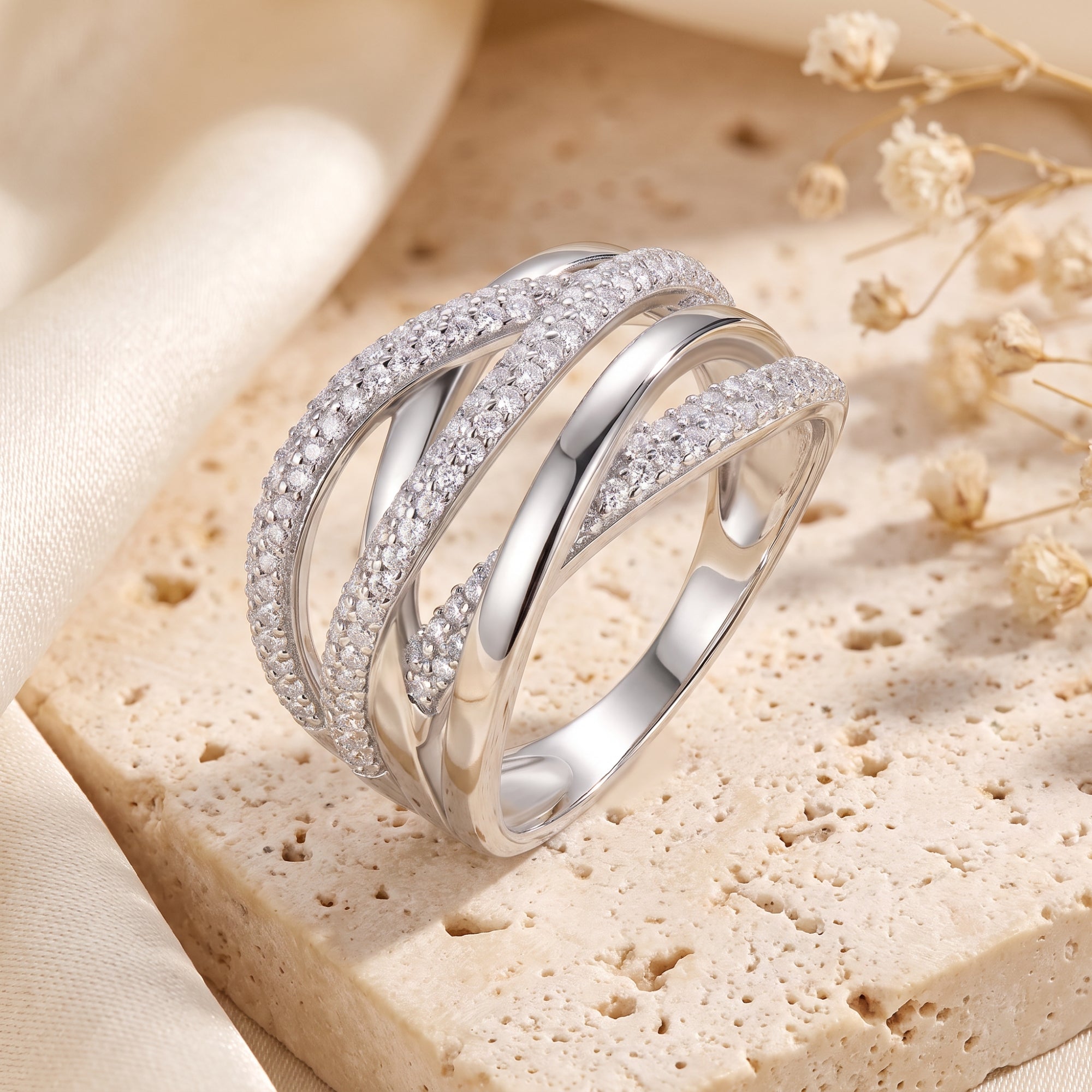 Close-up of silver crossover ring with interlocking pavé simulated diamond bands.