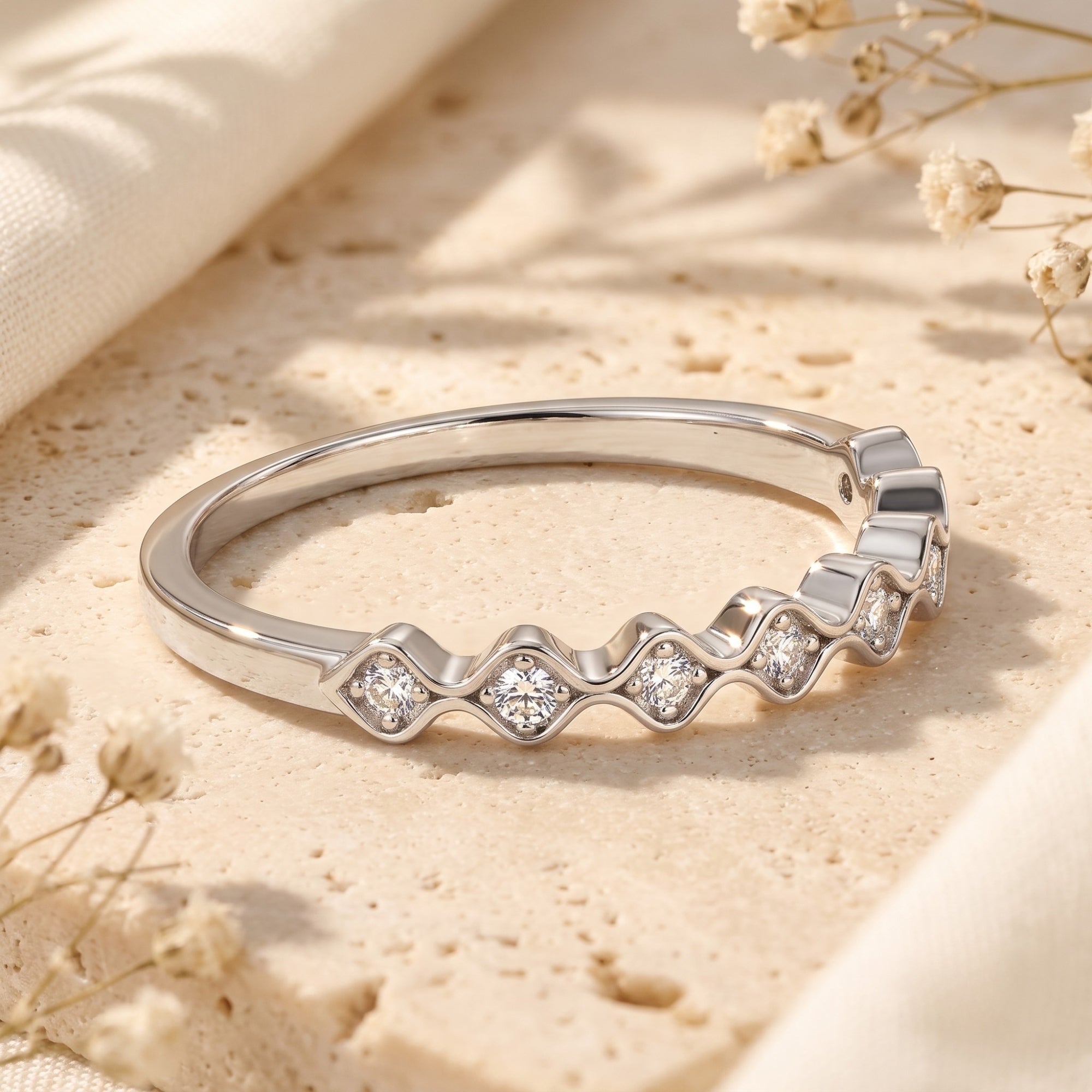 Close-up of the wavy sterling silver band and round-cut simulated diamond settings.