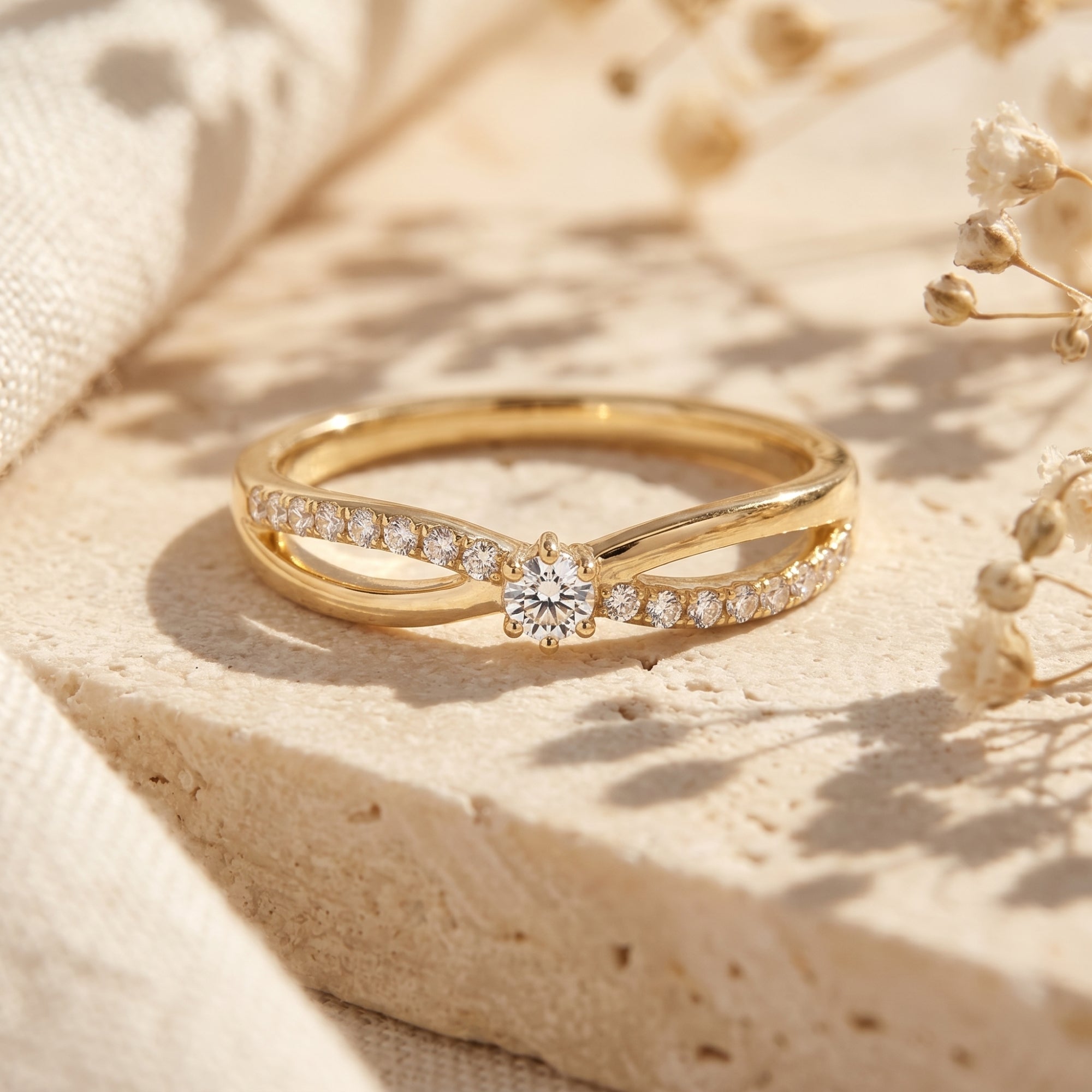 Gold bypass promise ring with round-cut moissanite on a textured background.