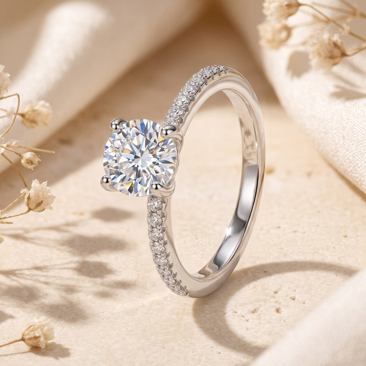 Angled close-up of the silver ring showing its four-prong round center stone, polished inner band, and shoulder accents.
