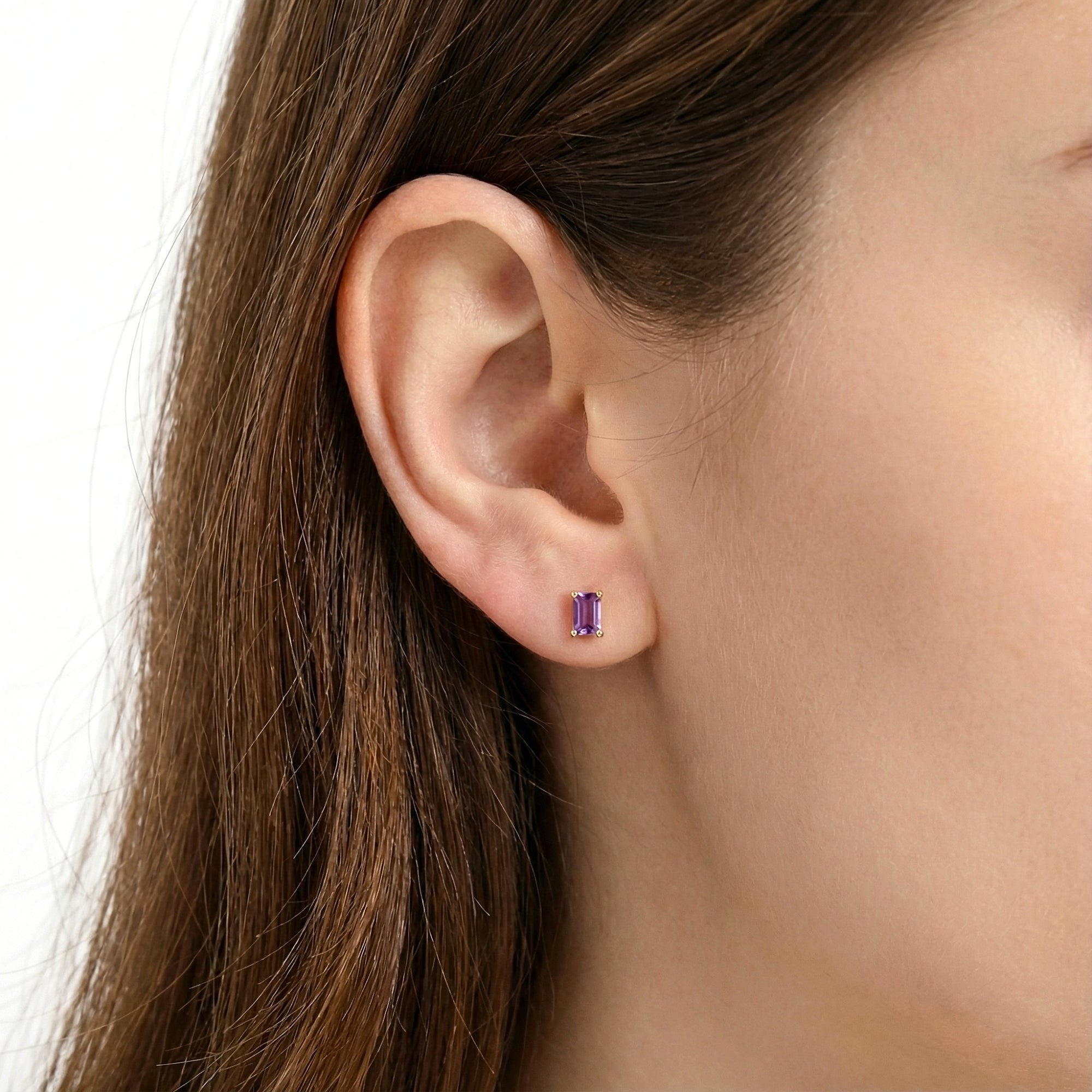 Model wearing a single emerald cut simulated amethyst stud earring in 18K gold vermeil.