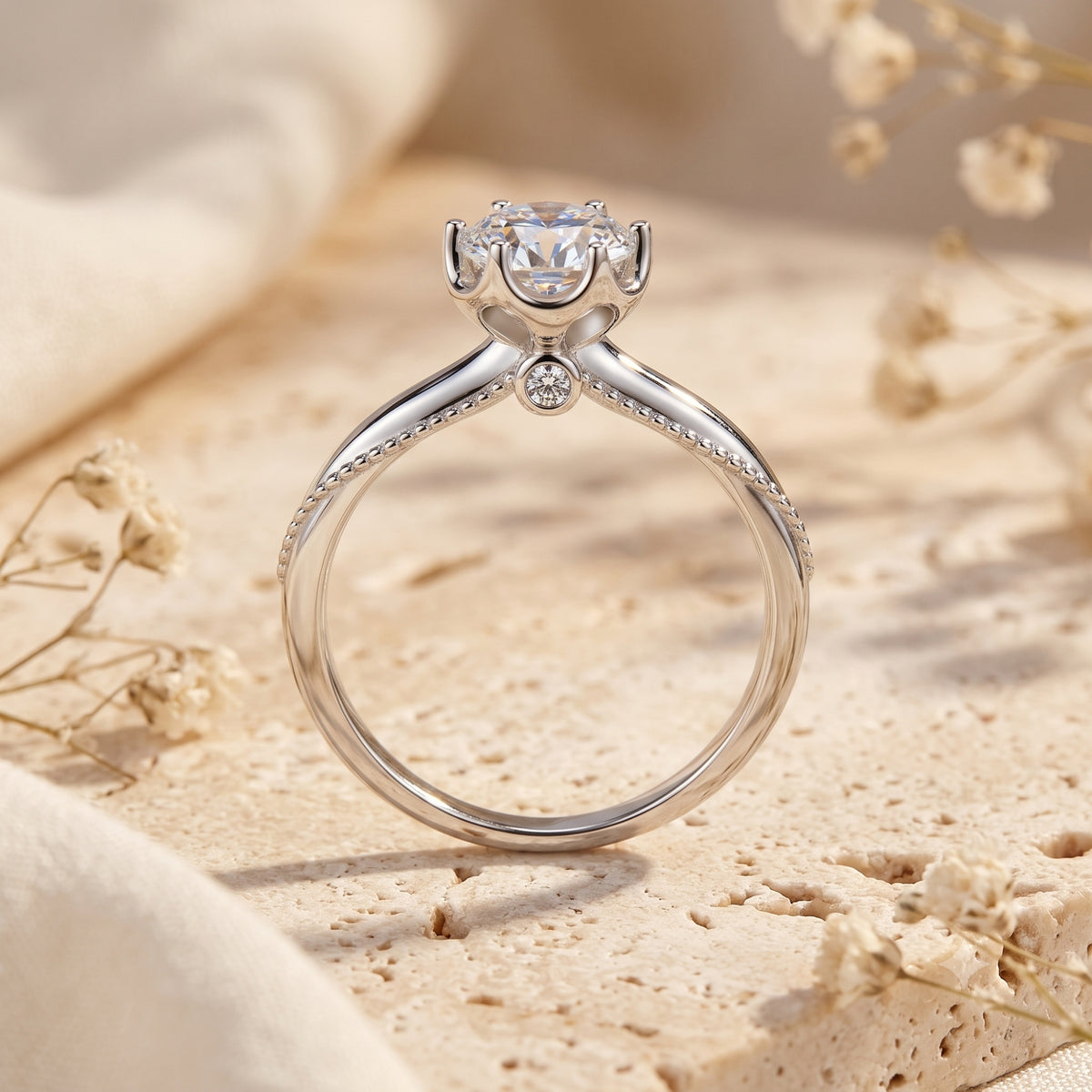 Rear view of a silver ring showing its crown-prong setting, small round accent stone, and milgrain shoulders.