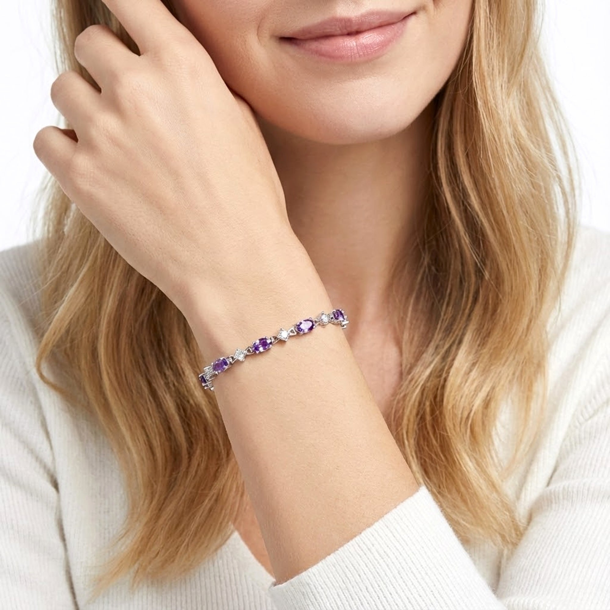 Woman wearing the Lucina S925 sterling silver tennis bracelet with oval purple simulated amethyst stones on her wrist.