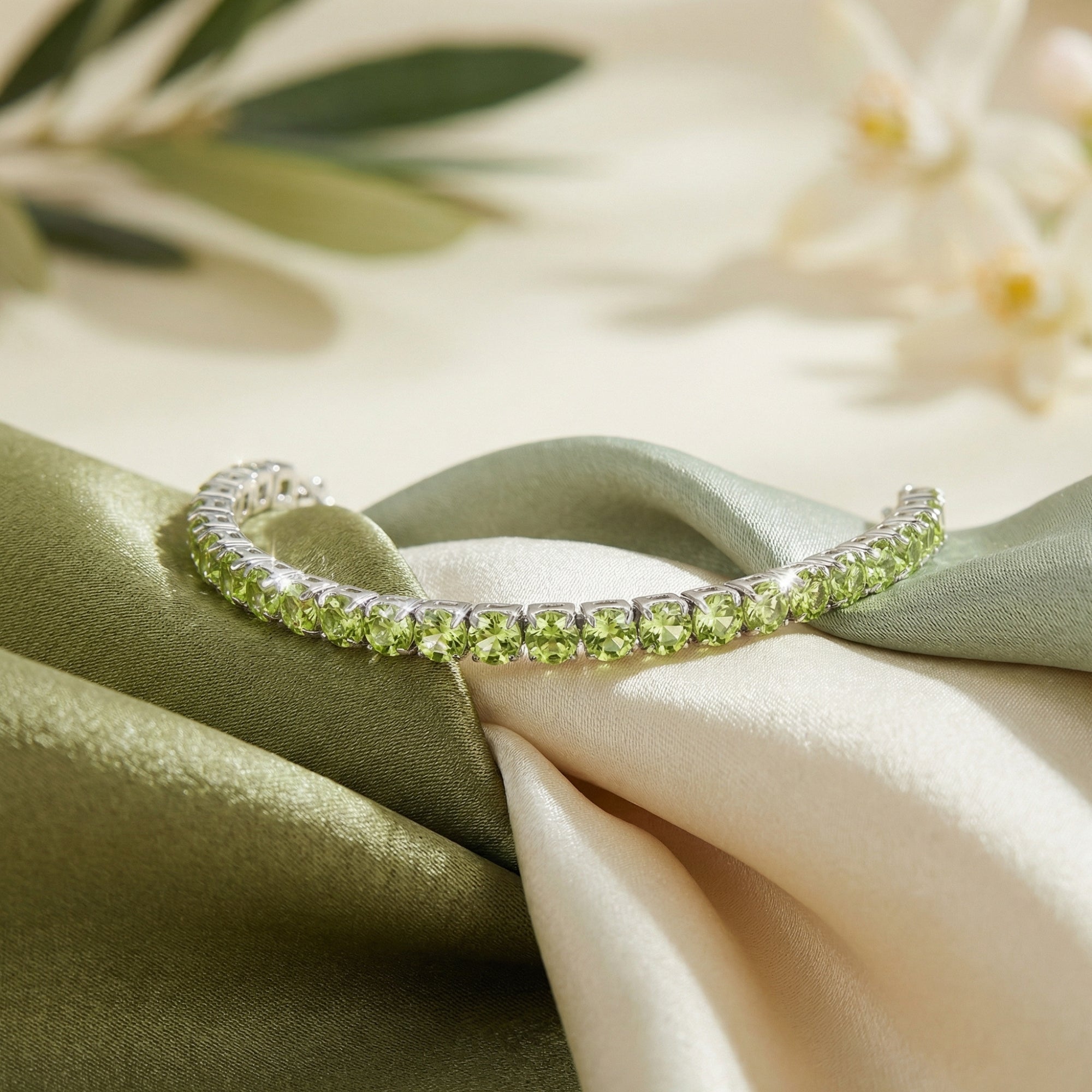 Macro view of round cut natural peridot gemstones in a sterling silver prong setting on draped silk.