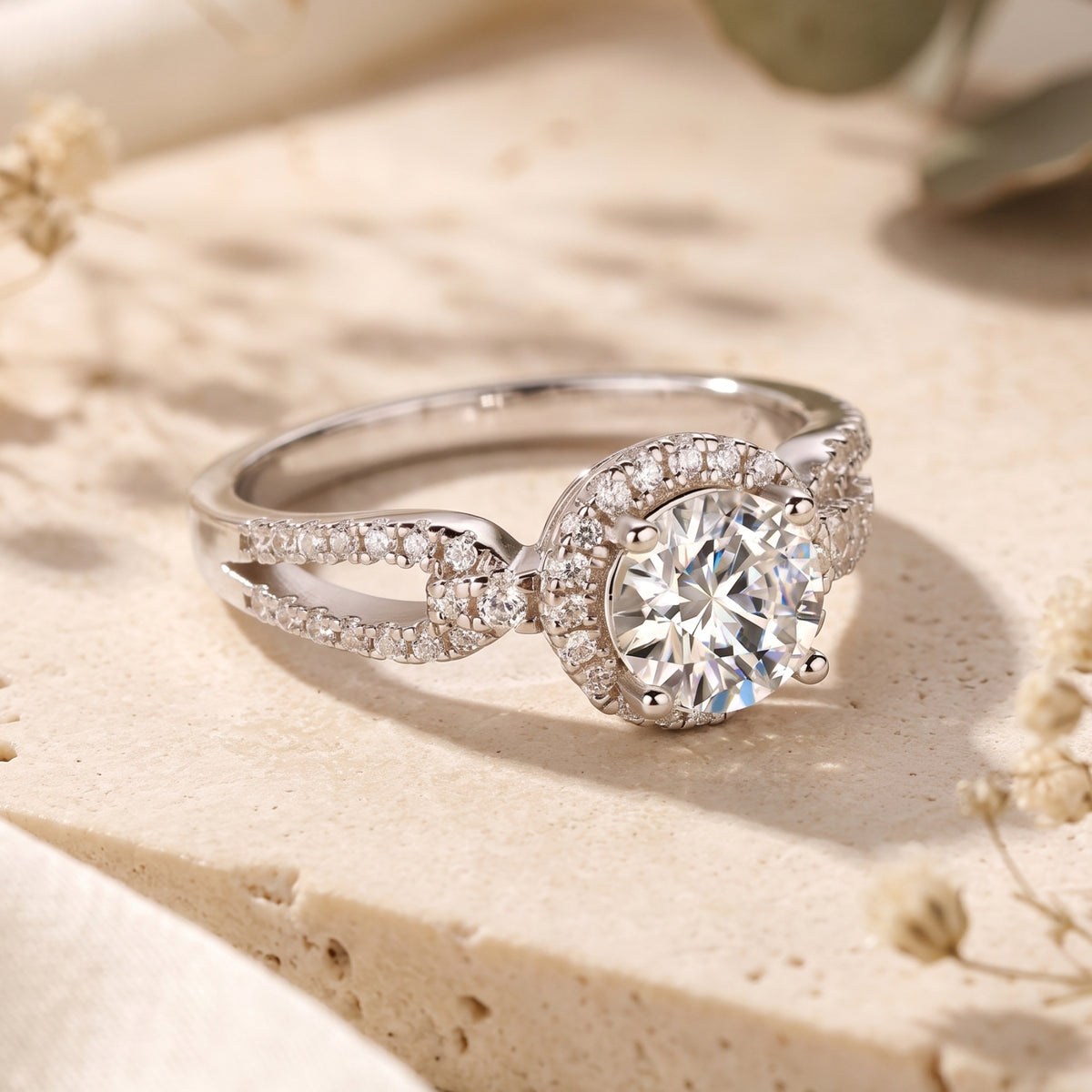 Three-quarter view of the silver halo ring with a round center stone and split-shank infinity twist band.