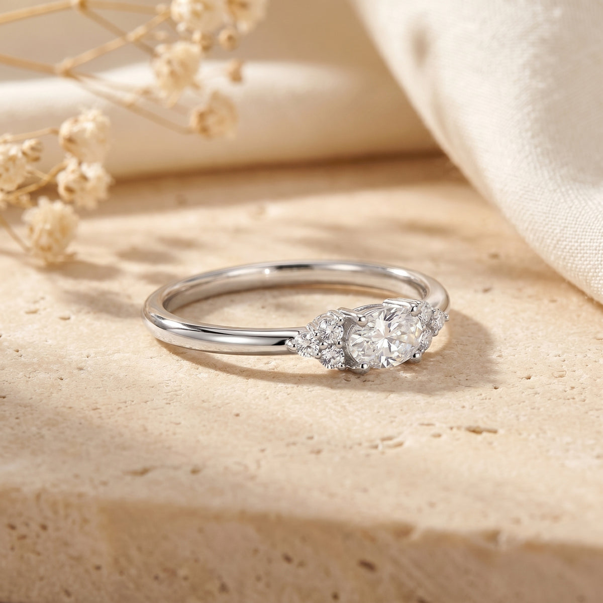 Side view detail of the 1-carat oval moissanite stone and silver cluster setting.