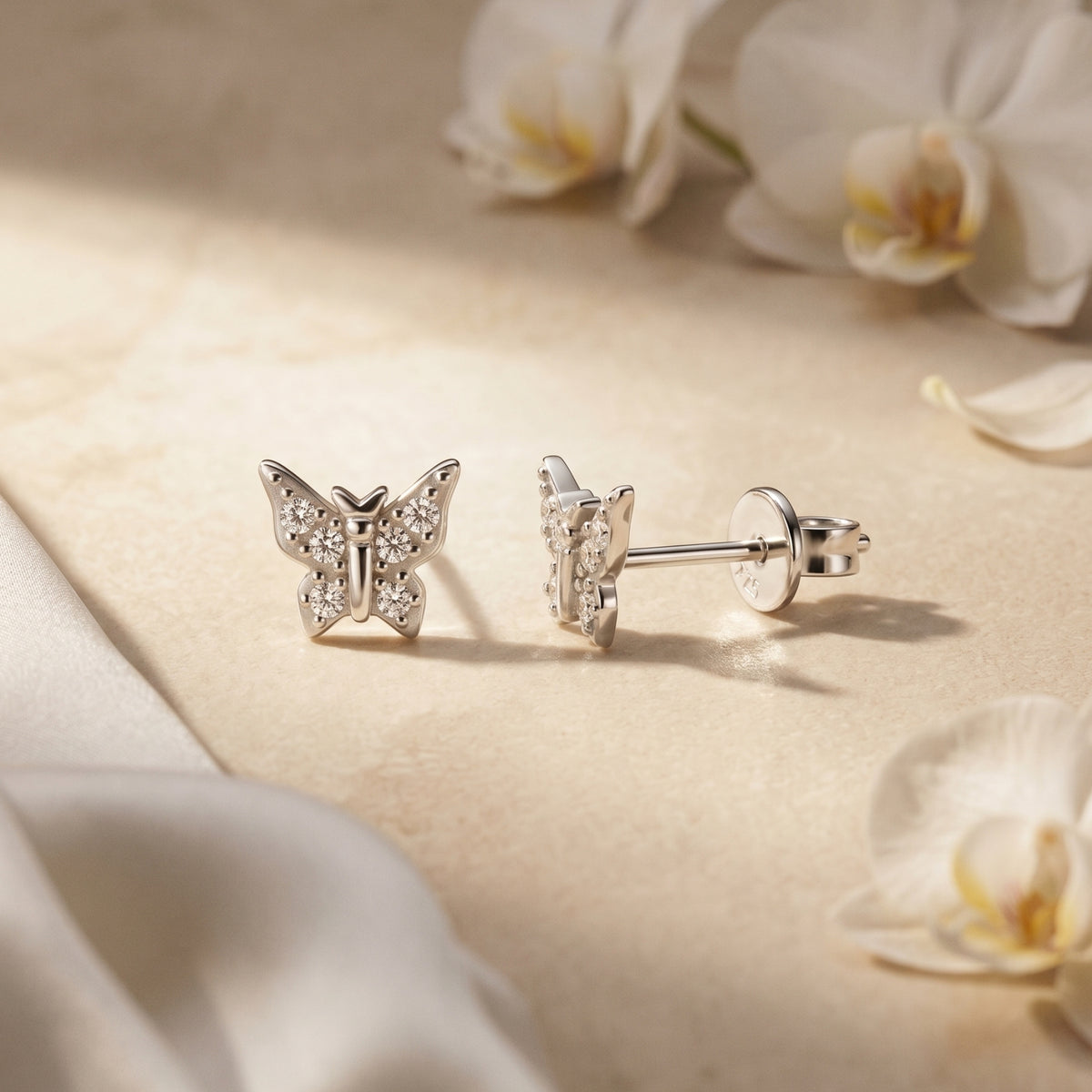 Silver moissanite butterfly studs, front and side views.