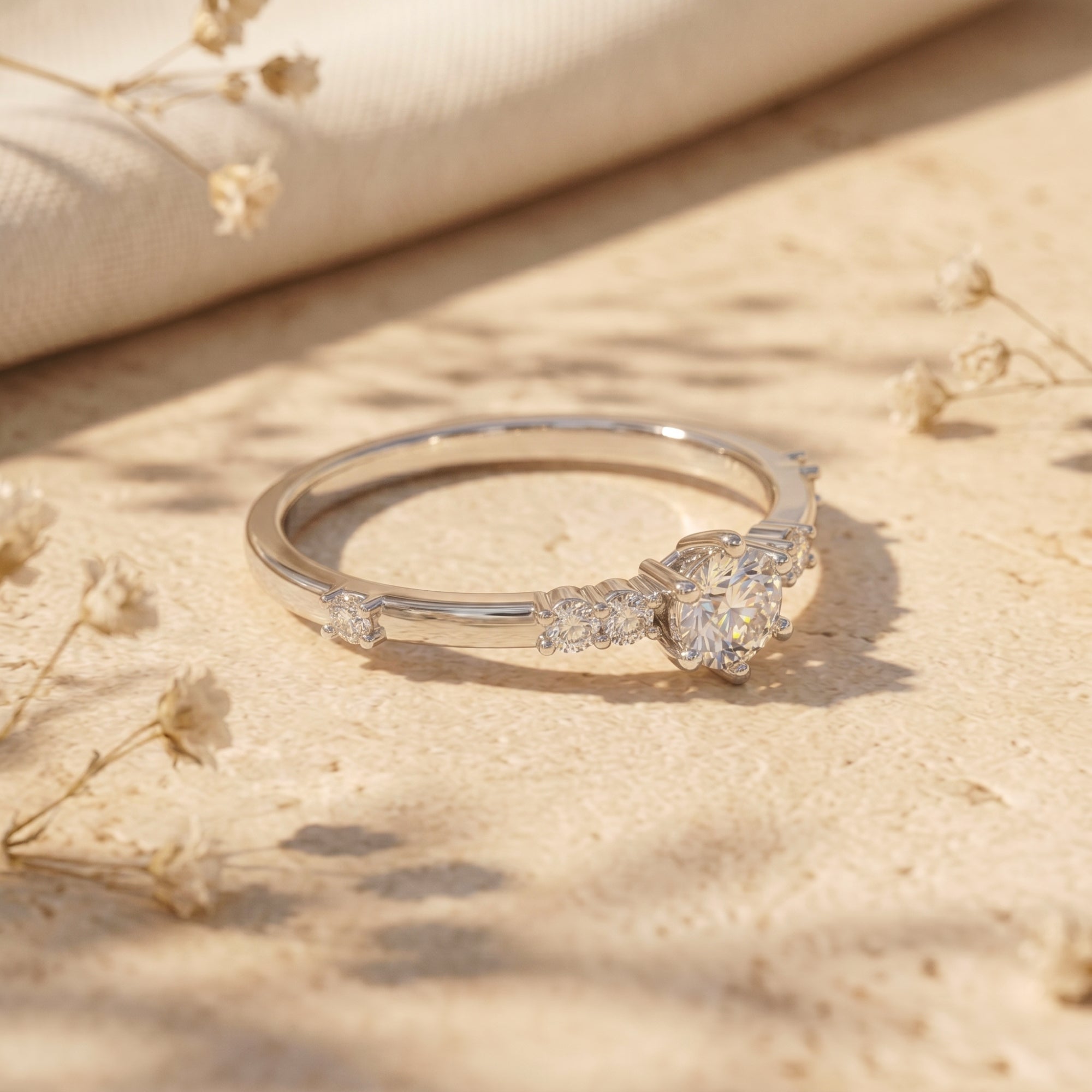 Side profile of a round cut moissanite ring in S925 sterling silver showing the prong setting and side stones.