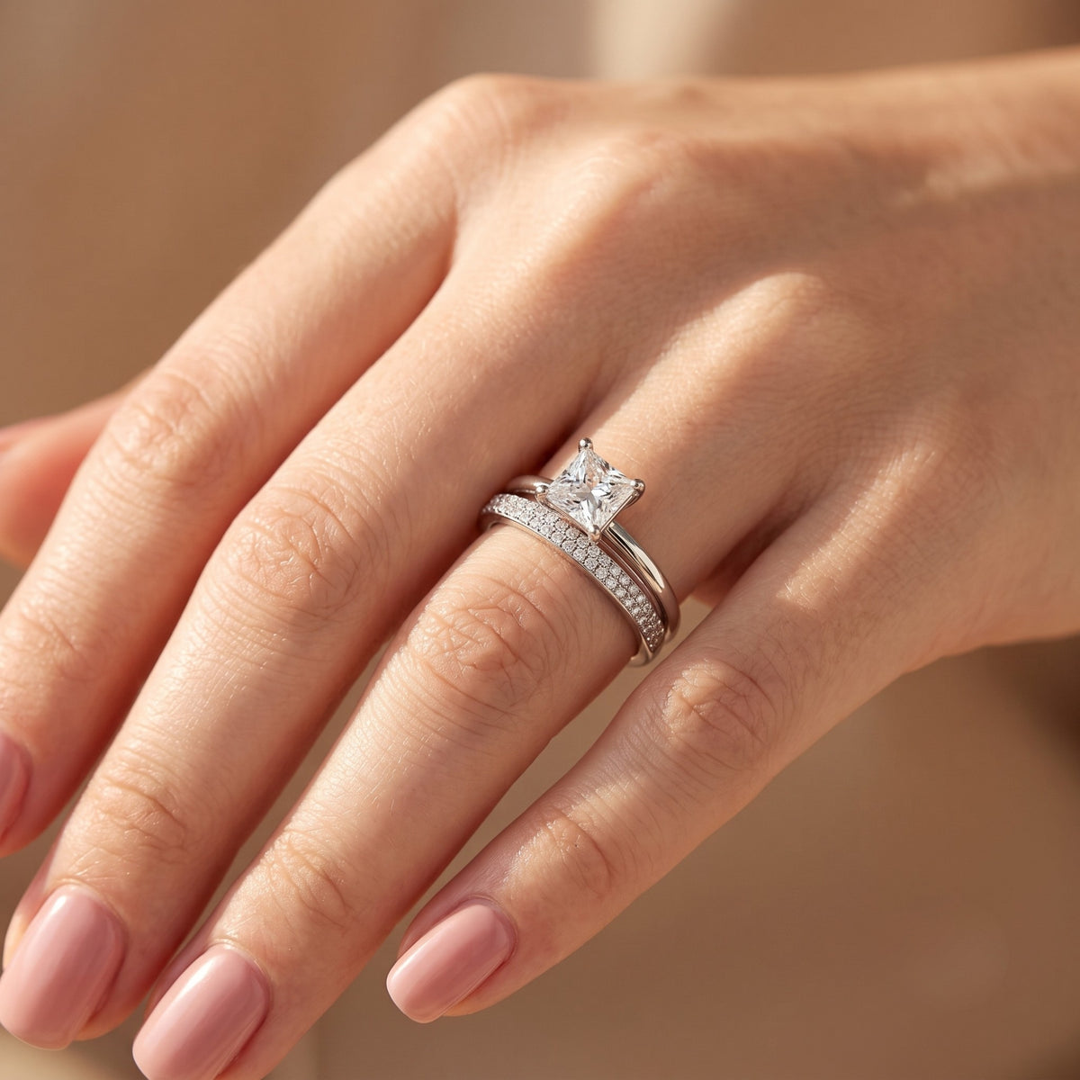 Sterling silver princess cut simulated diamond ring set worn on a woman's hand.