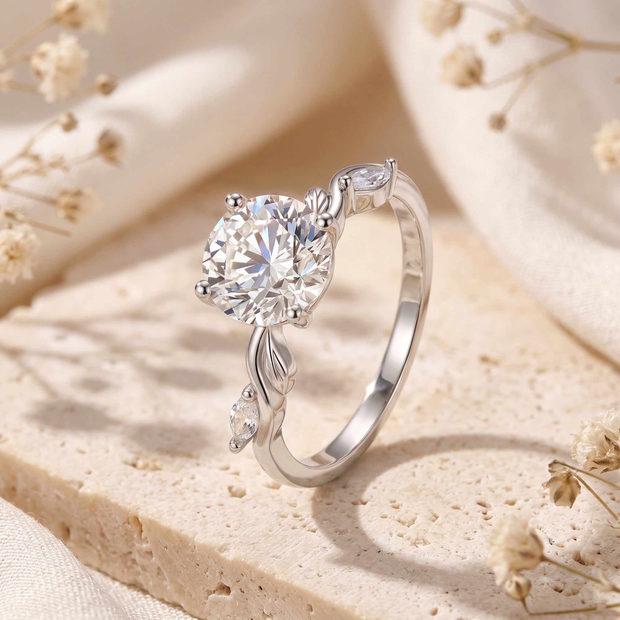 Macro view of sterling silver ring featuring a round-cut stone and organic leaf-shaped band details.