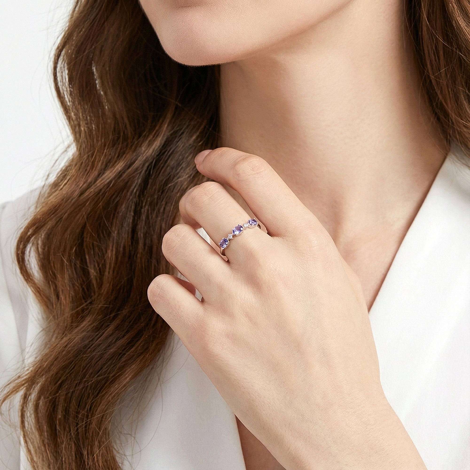 Model wearing the Serenitas S925 sterling silver ring with oval simulated amethysts on her ring finger.