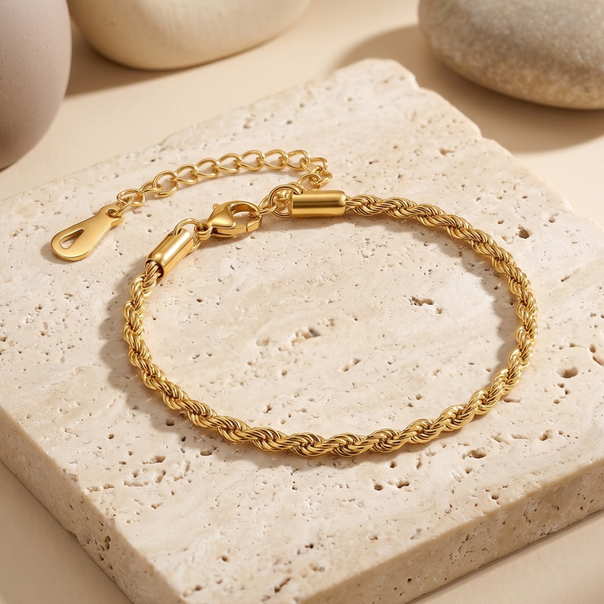 Detail of the gold rope bracelet's adjustable extender and lobster clasp on stone.