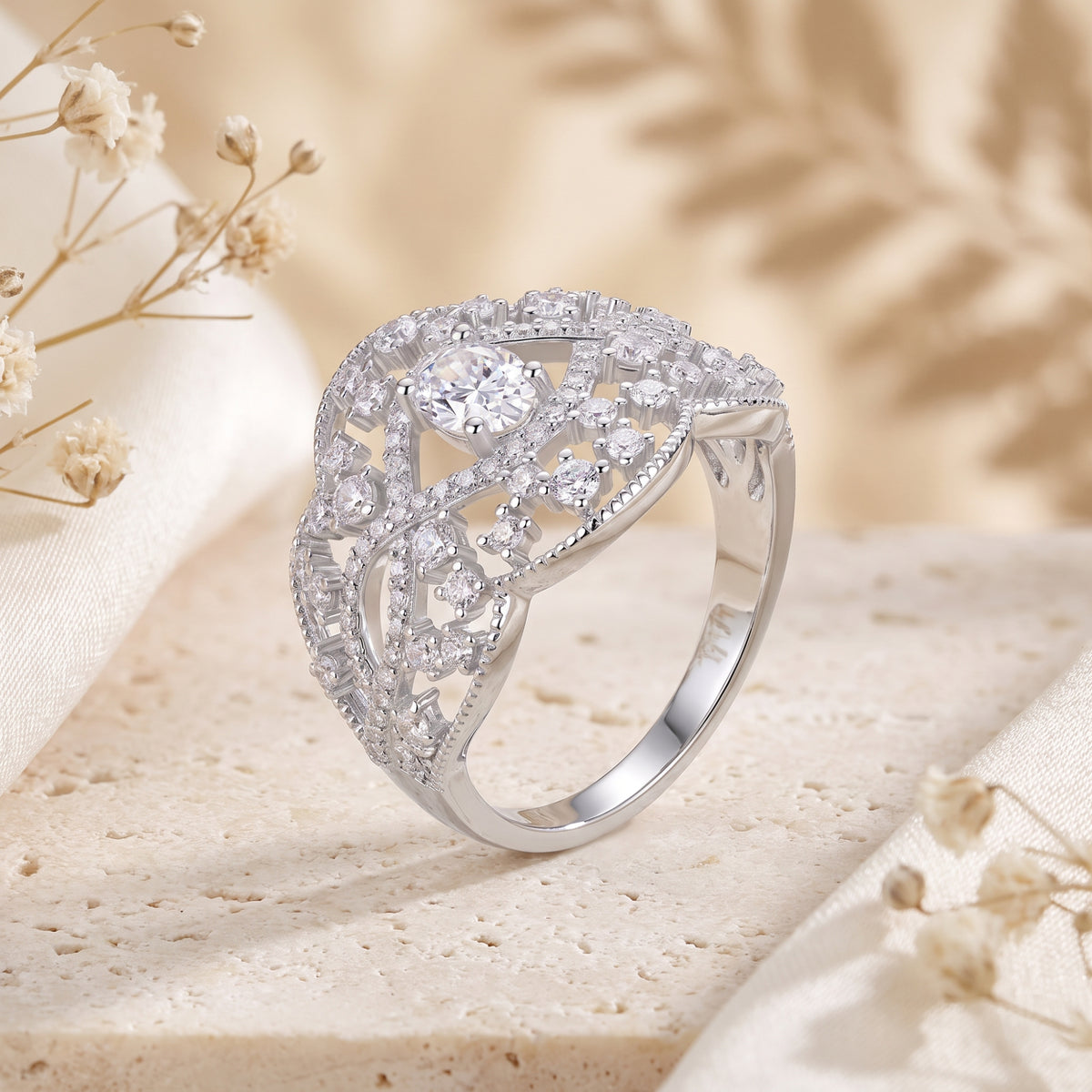 Angled view of the silver openwork lace ring highlighting the band profile and detailed gemstone settings.