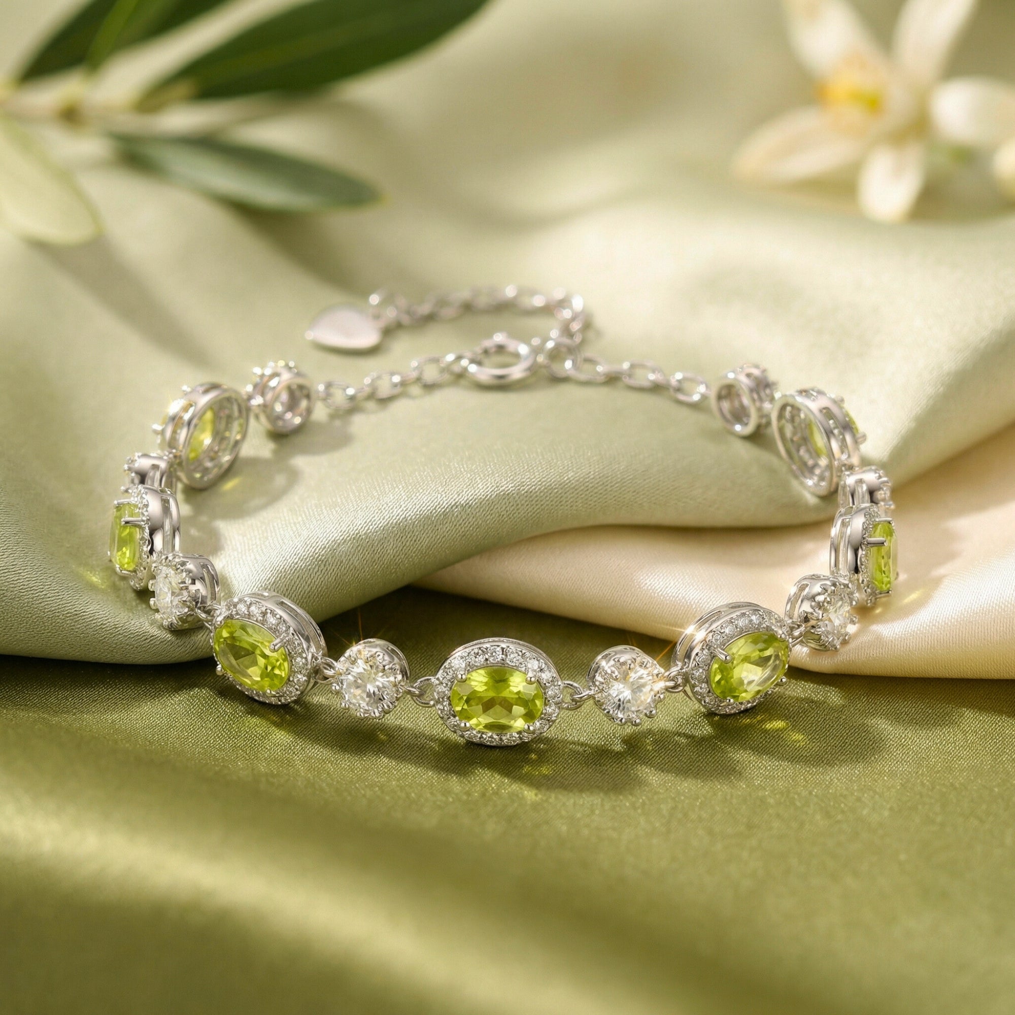 Close-up of oval-cut natural peridot gemstones in an S925 sterling silver bracelet setting on green silk.