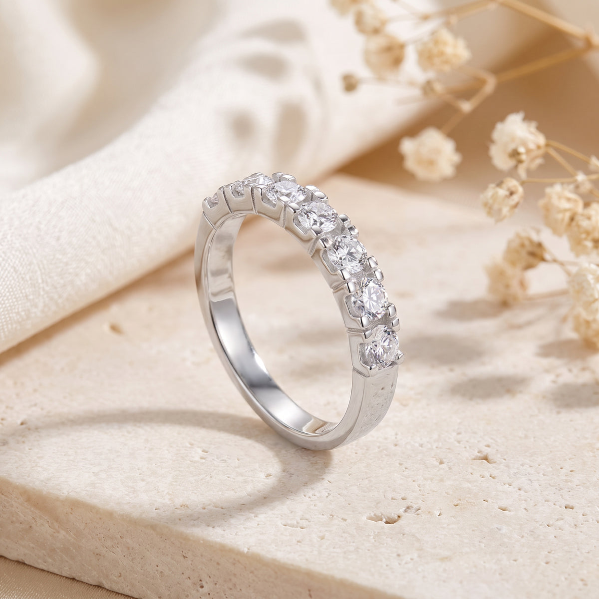 Angled studio view of the silver ring, showing the side setting and smooth polished band.