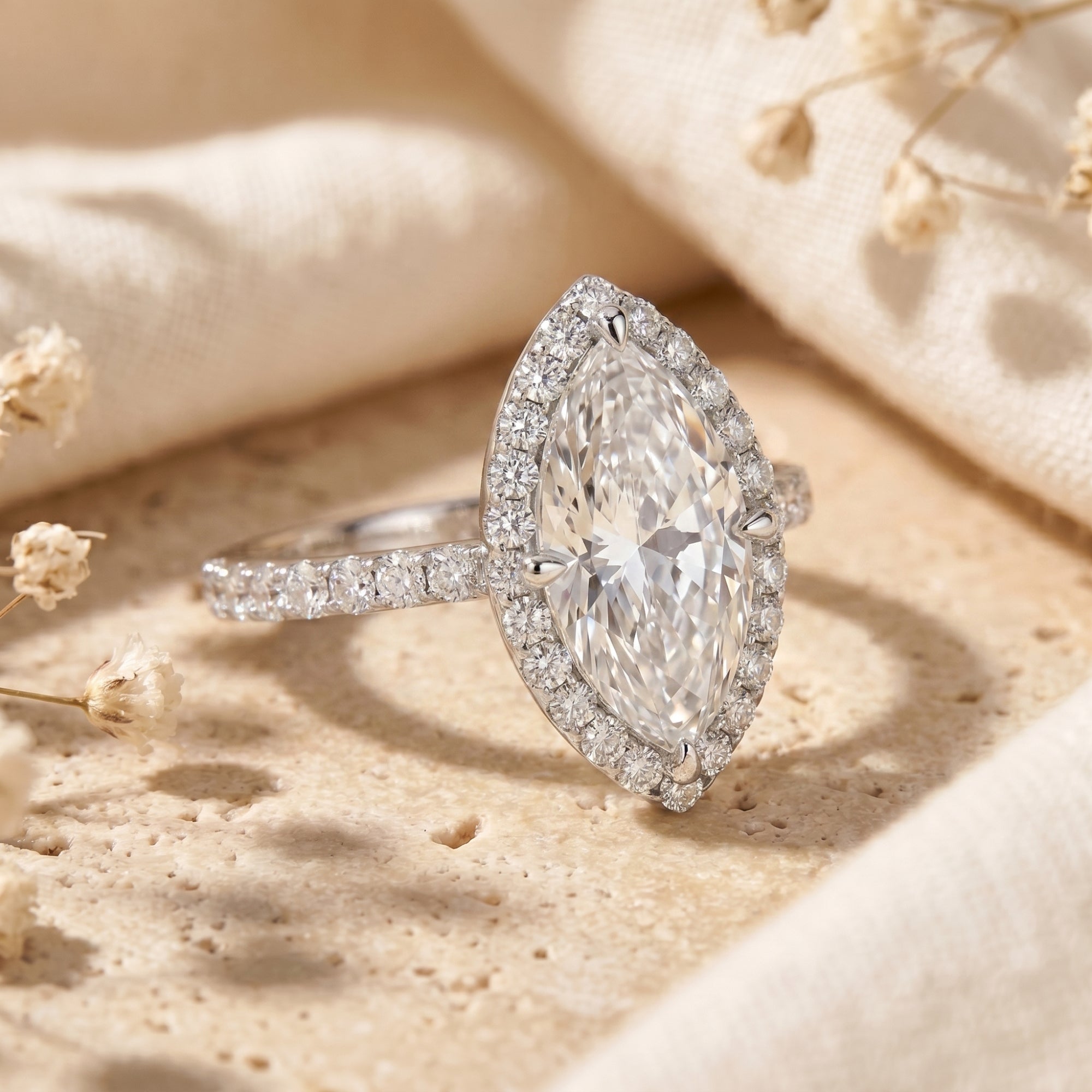 Close-up of a marquise cut moissanite halo ring in sterling silver showing side detail.