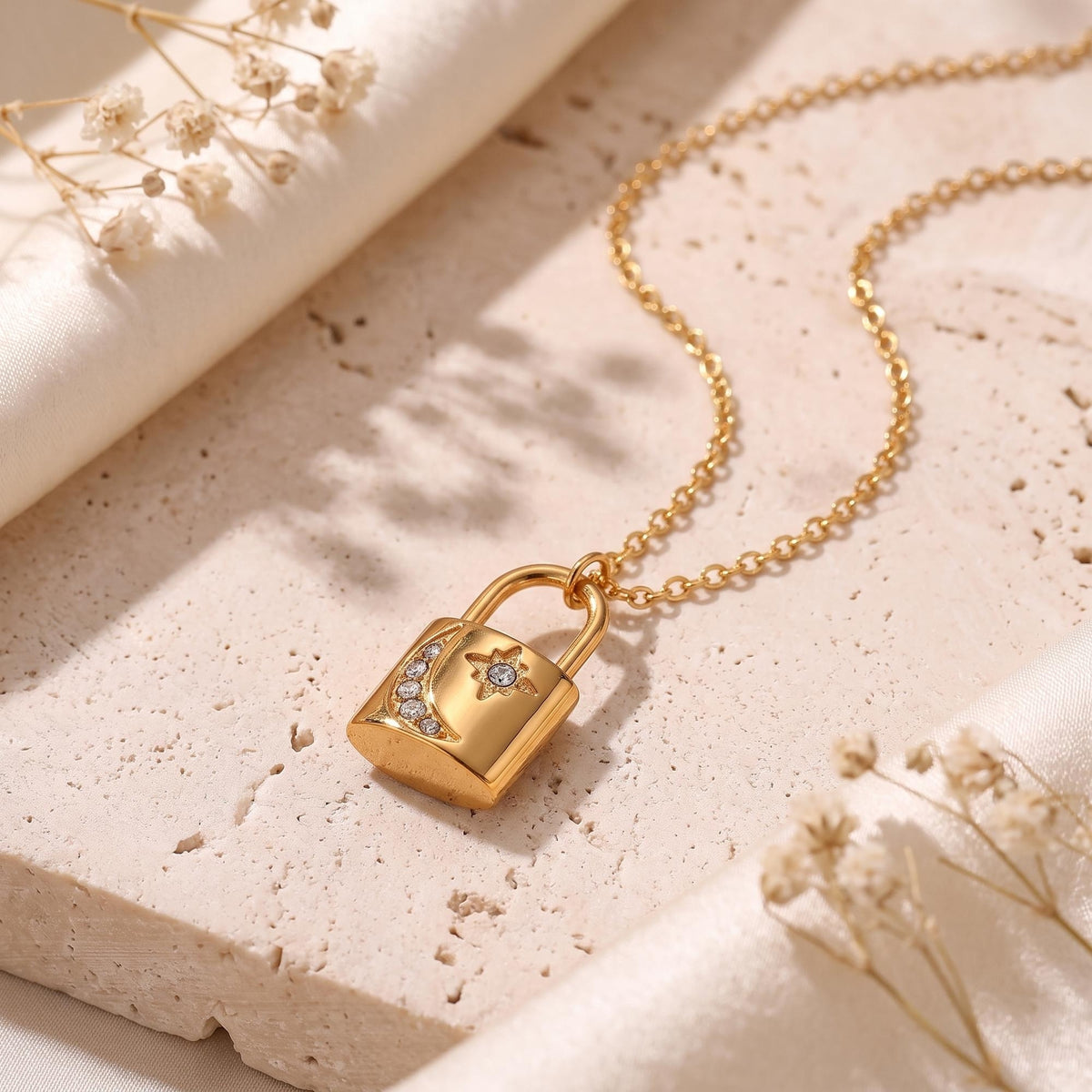 Close-up of the 18K gold padlock pendant featuring a crystal crescent moon and star.