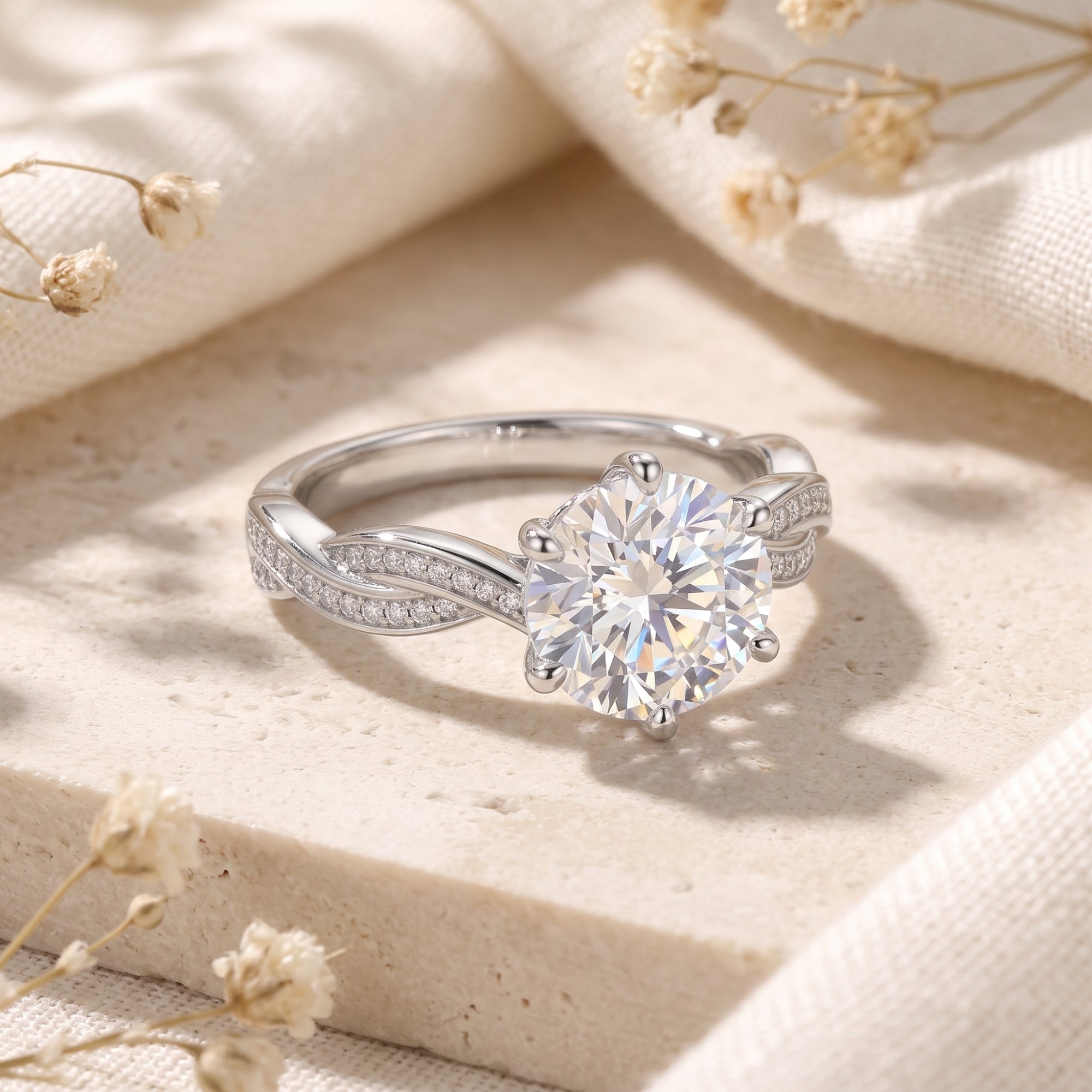 Close-up of a 9mm round-cut simulated diamond ring in sterling silver with a pavé infinity-style band.