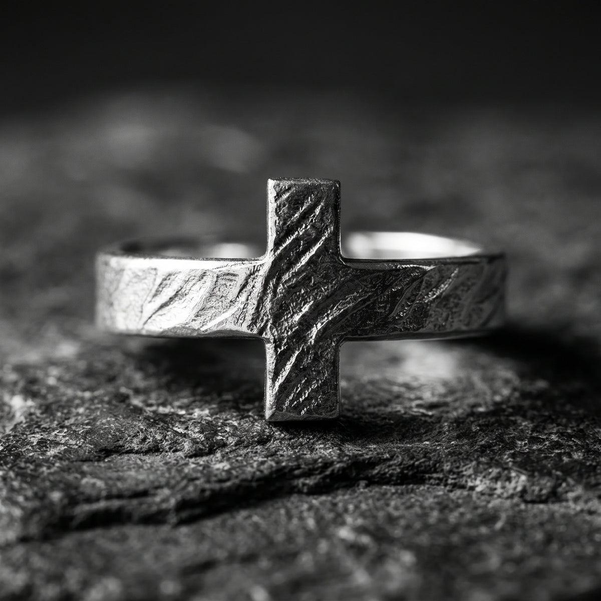 Front view of the textured cross ring displayed on a dark stone surface.