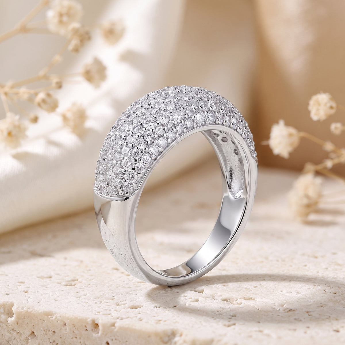 Macro view of a solid white gold dome ring's micro-pave setting and cubic zirconia stones.