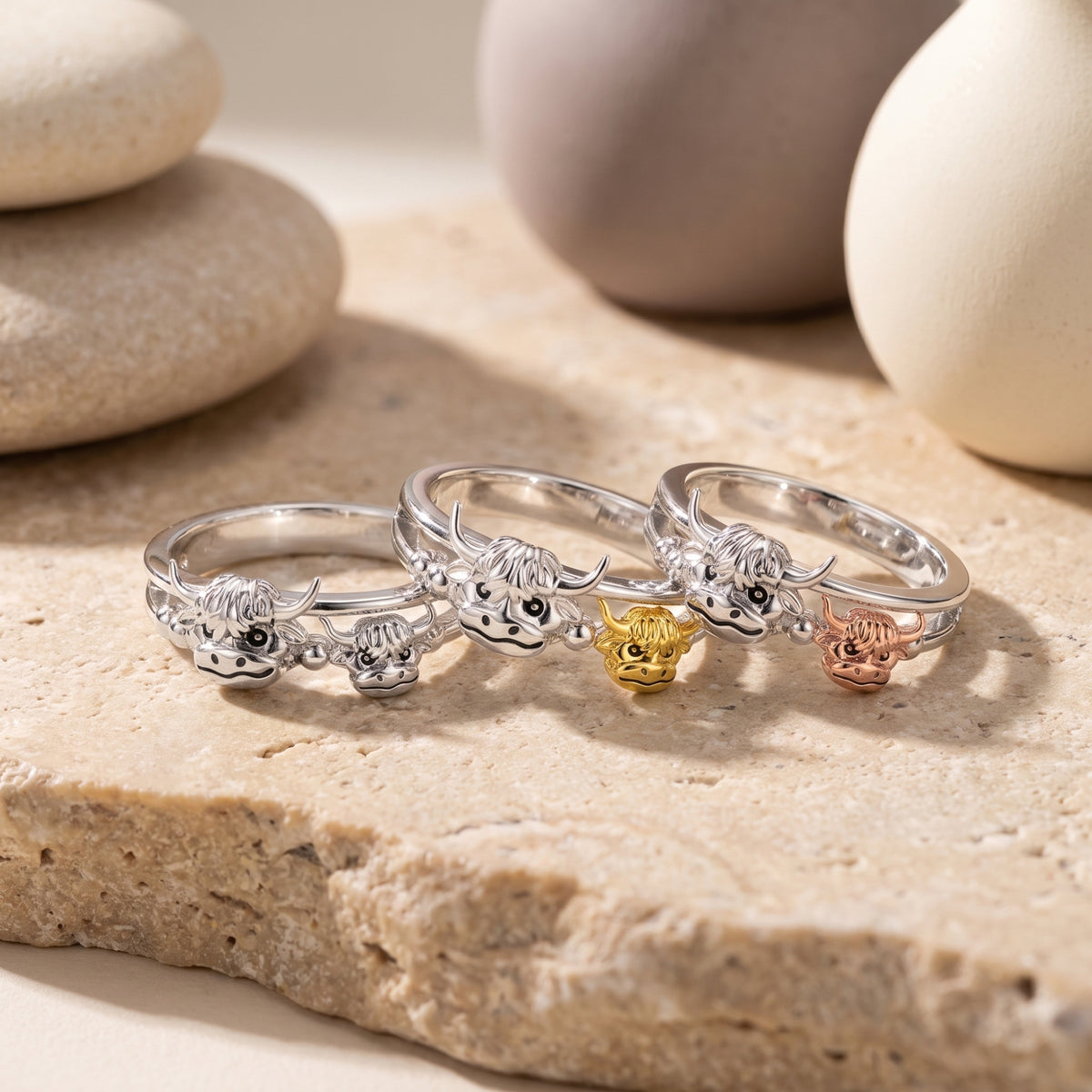 Three highland cow rings shown together with silver-tone, gold-tone, and rose gold-tone calf accents.