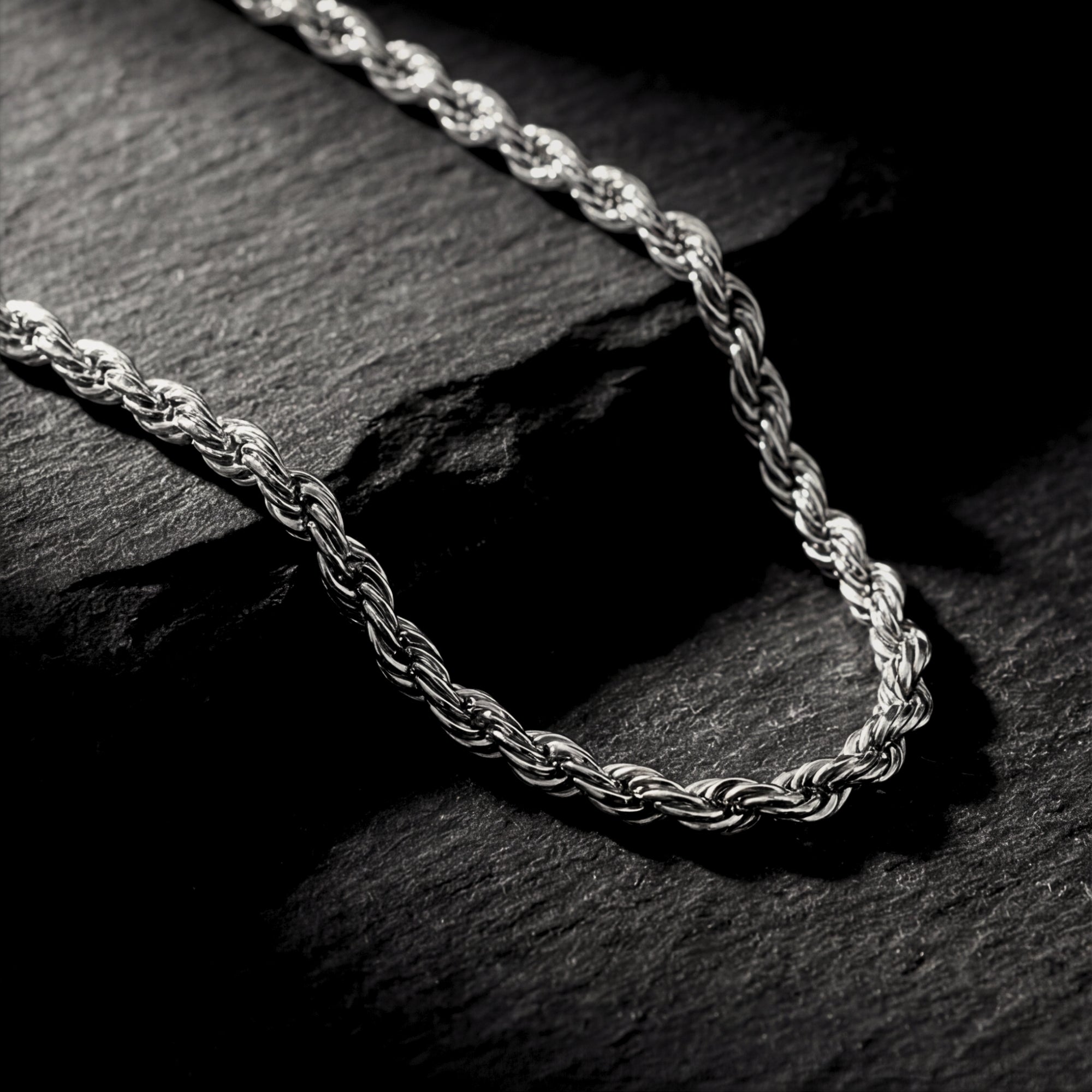 Macro detail shot of the twisted links on a silver stainless steel rope chain.