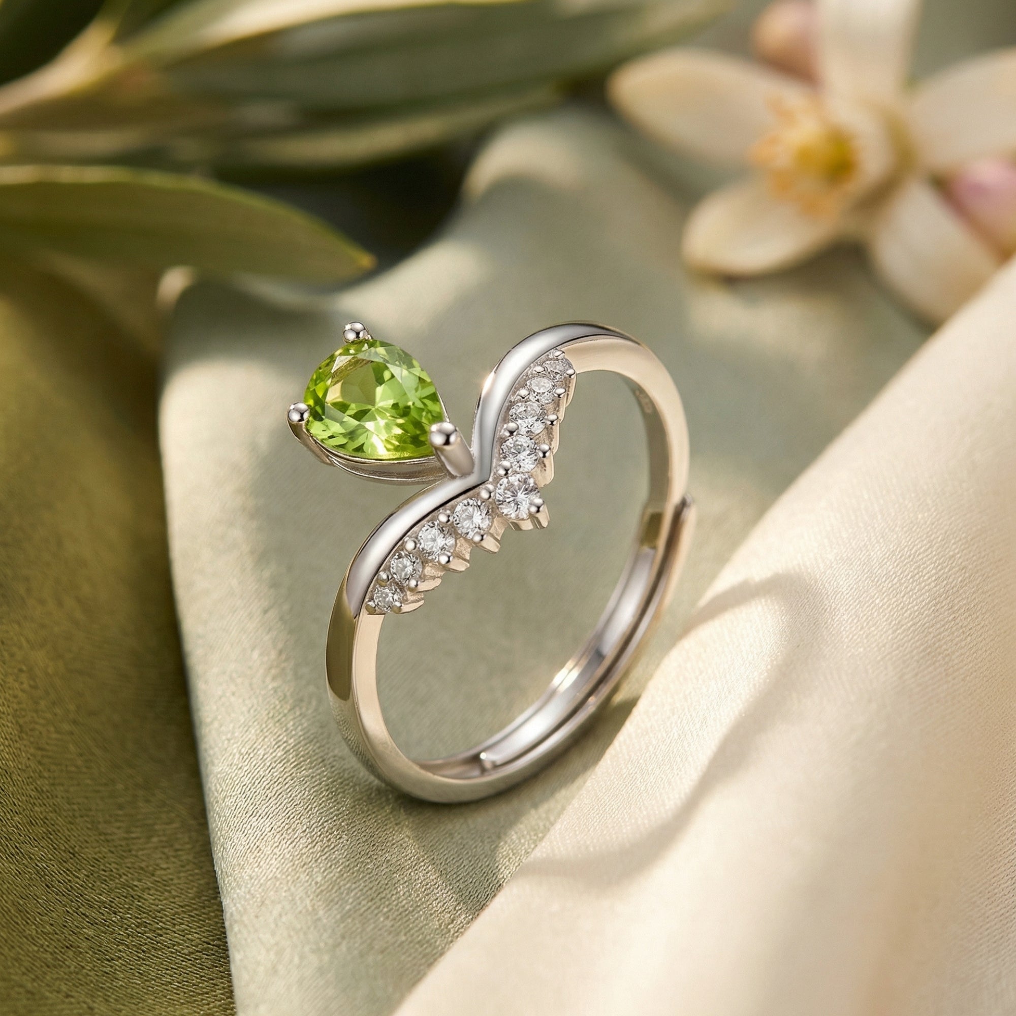 Side view detail of the natural pear cut peridot sterling silver ring showing the adjustable band and V-setting.