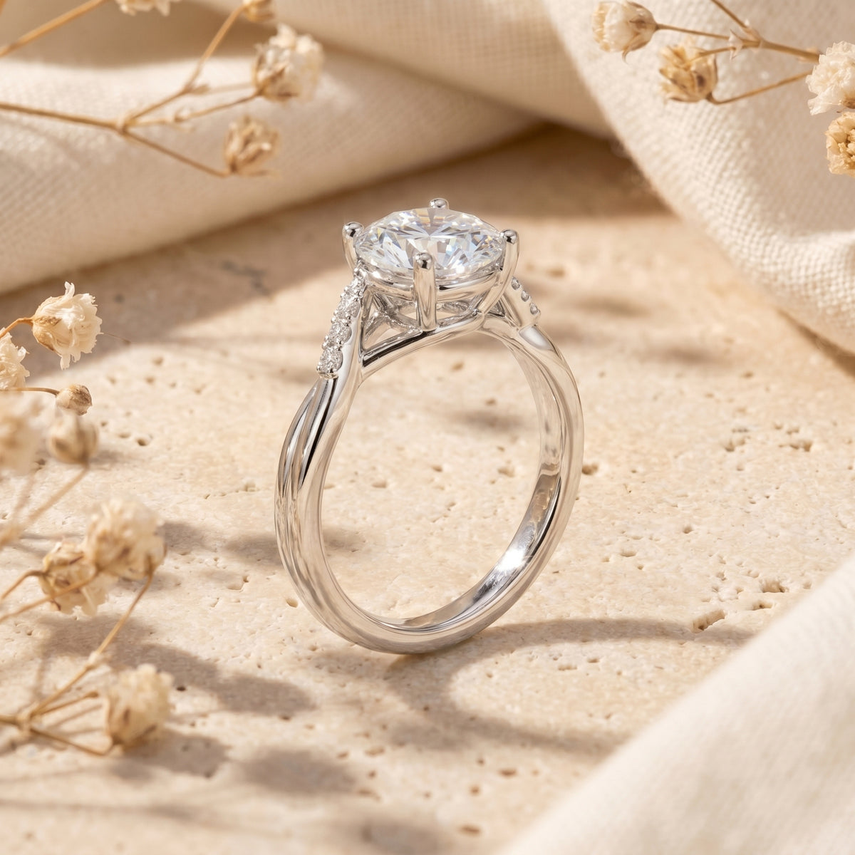 Side view of round moissanite ring in silver showing twisting band and accent stones on stone surface.