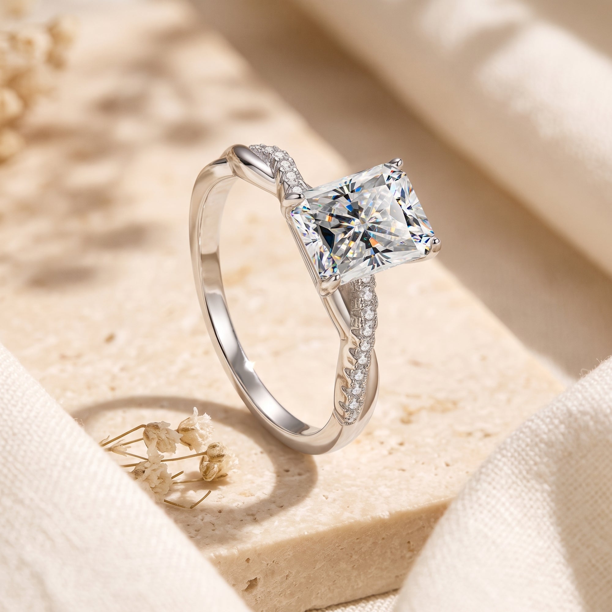Angled view of sterling silver radiant cut simulated diamond ring with twisted pavé setting.