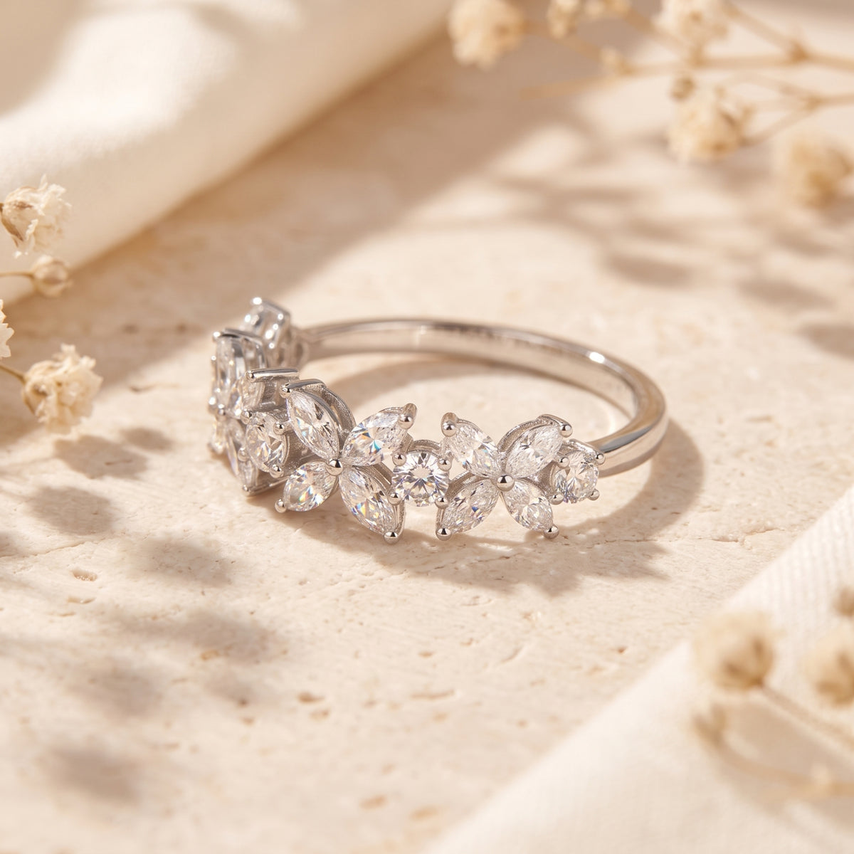 Close-up of silver floral promise ring highlighting marquise cut zircon stone settings.