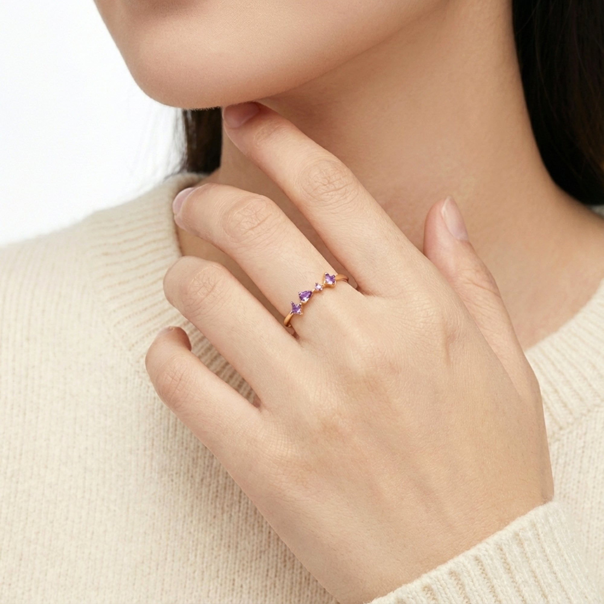 Model wearing the Elisia 18K gold vermeil ring with princess and pear cut simulated amethyst on her finger.
