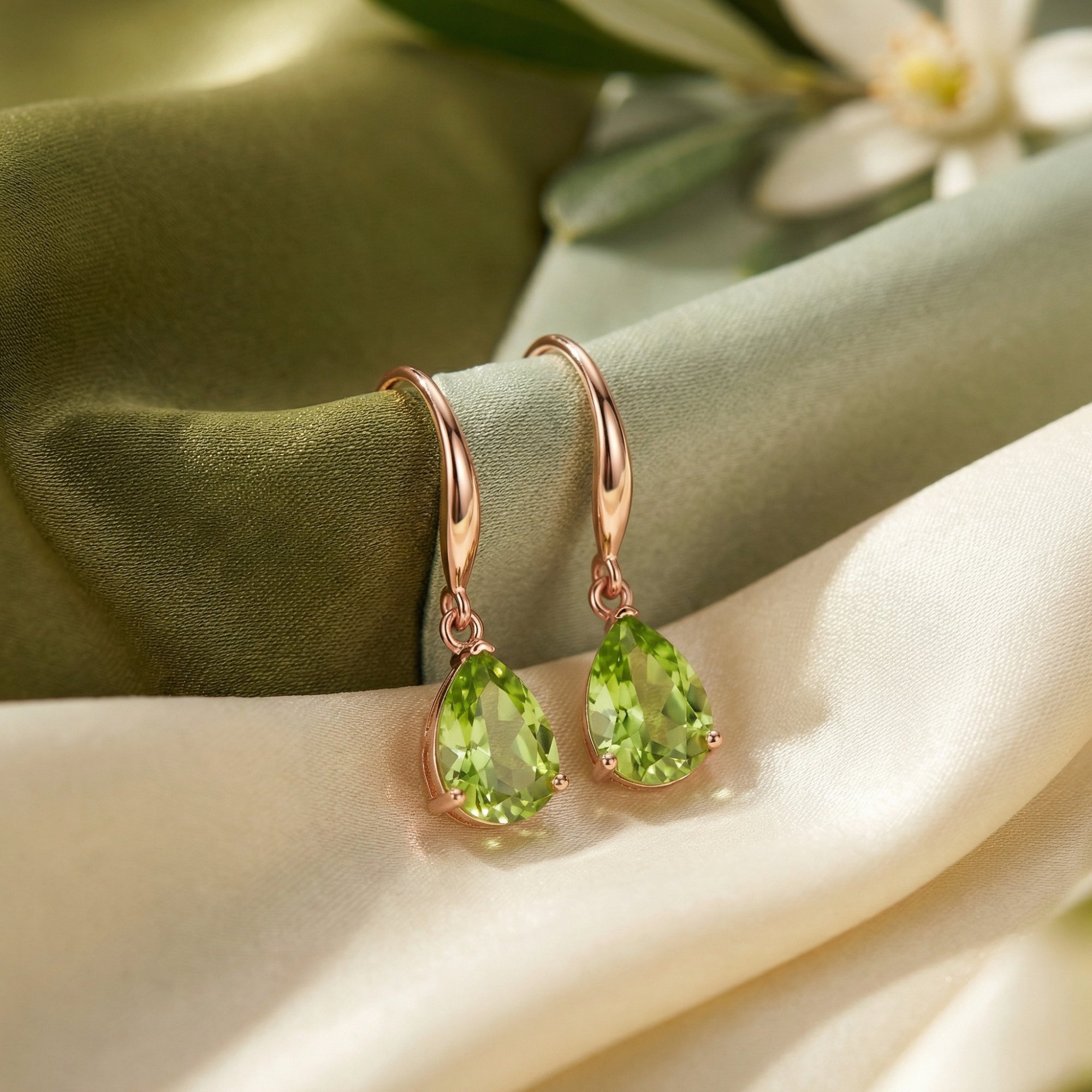 Macro view of pear cut natural peridot stones in 18K rose gold vermeil drop earring settings.