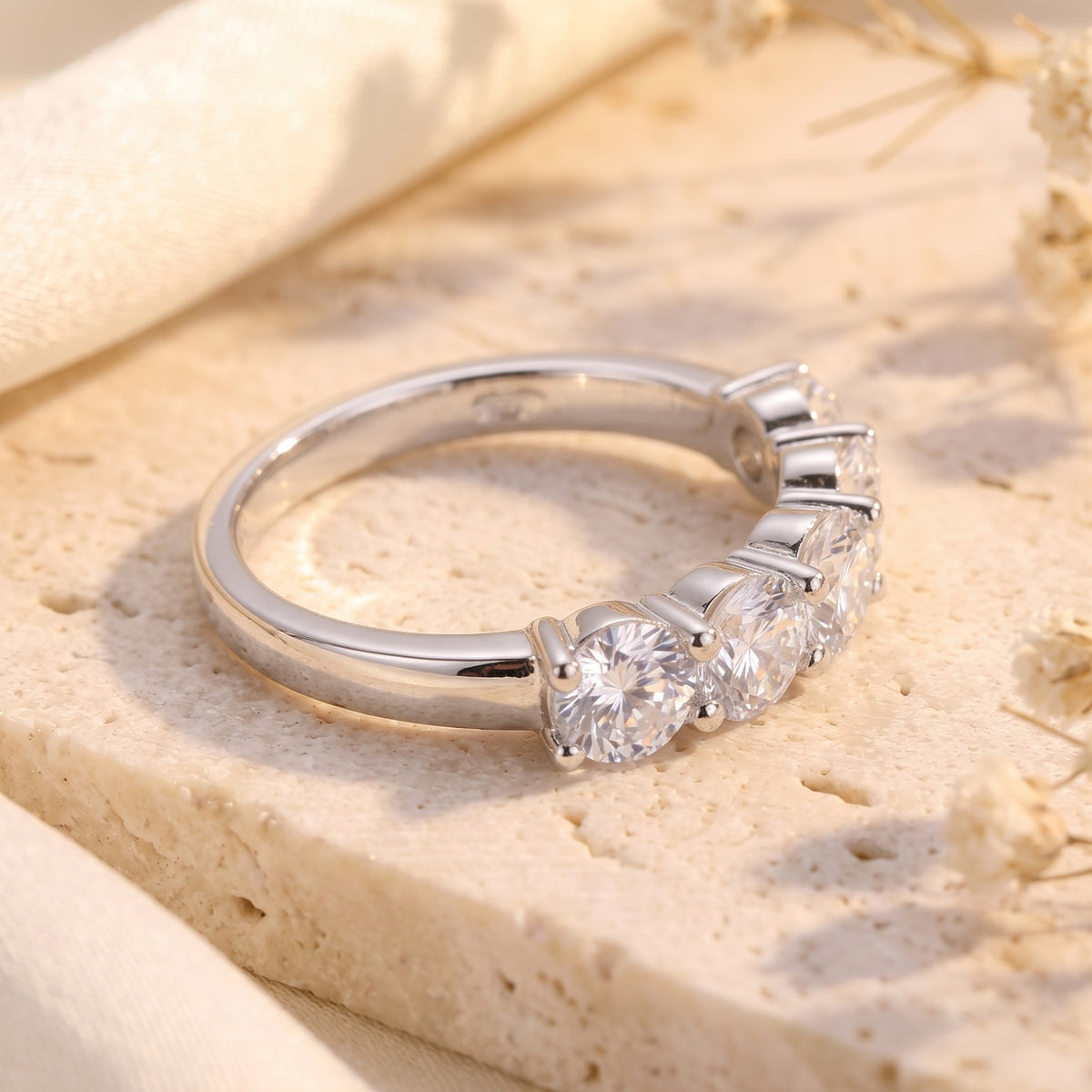Side angle view of the silver five-stone band ring showing the setting profile.