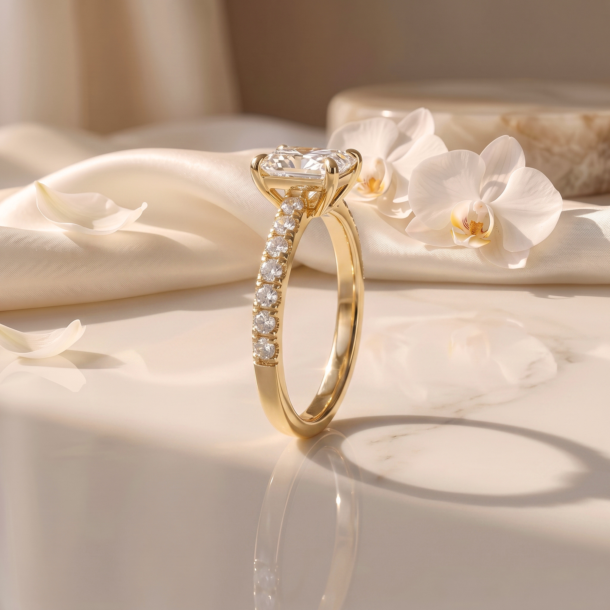 A side profile view of a radiant cut moissanite ring showcasing the intricate basket setting and pavé details on a yellow gold band.