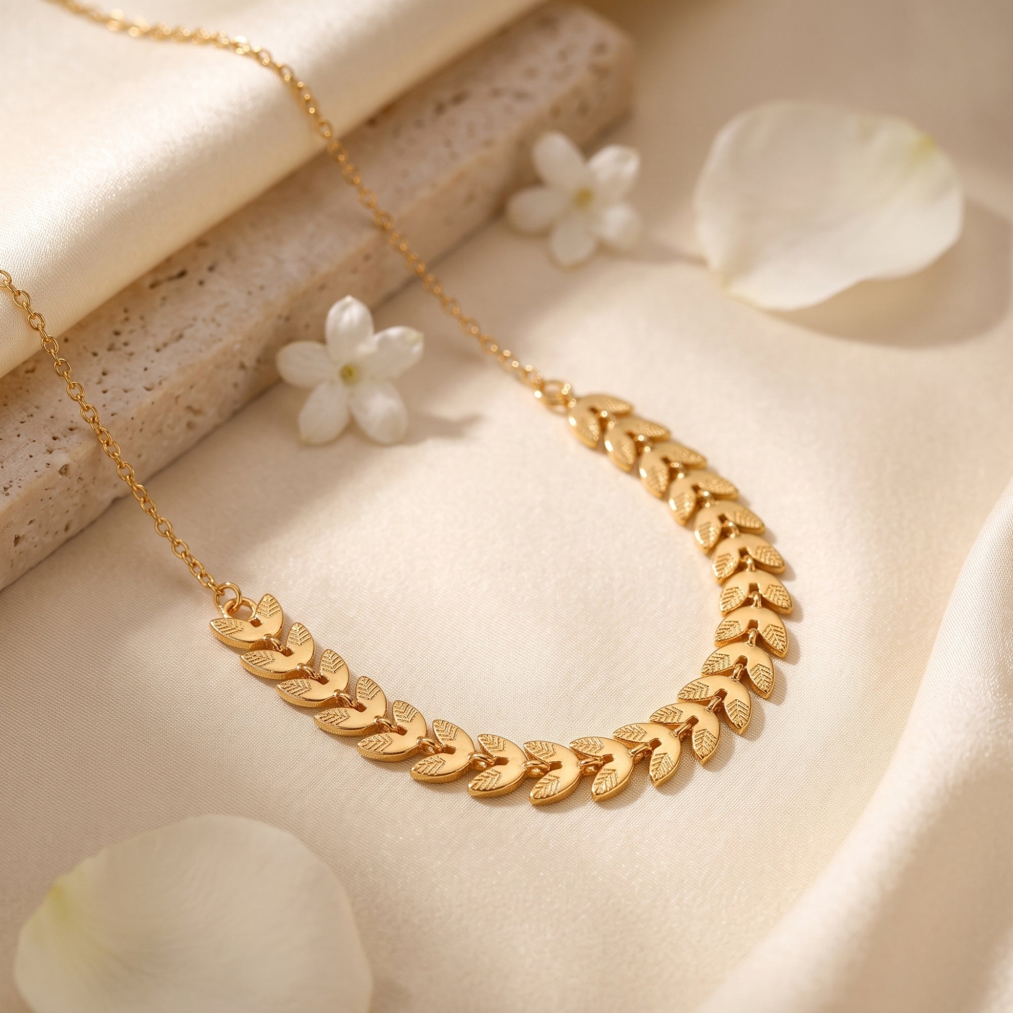 Macro view of textured gold leaf links on the Daphne necklace.