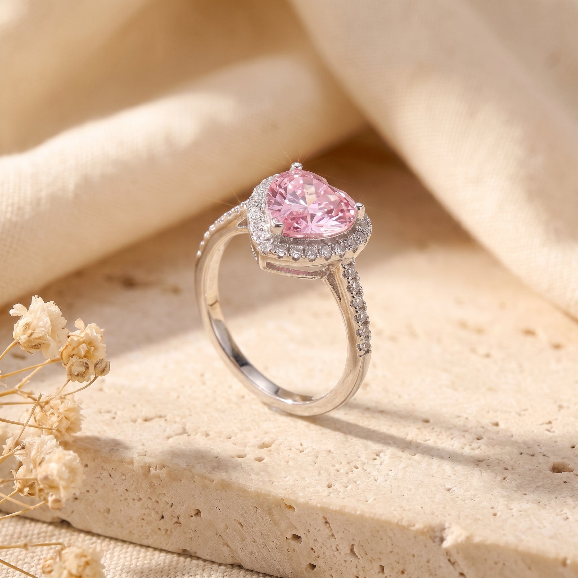 Side profile of the Amourette sterling silver ring with a heart-cut simulated pink tourmaline and halo setting.