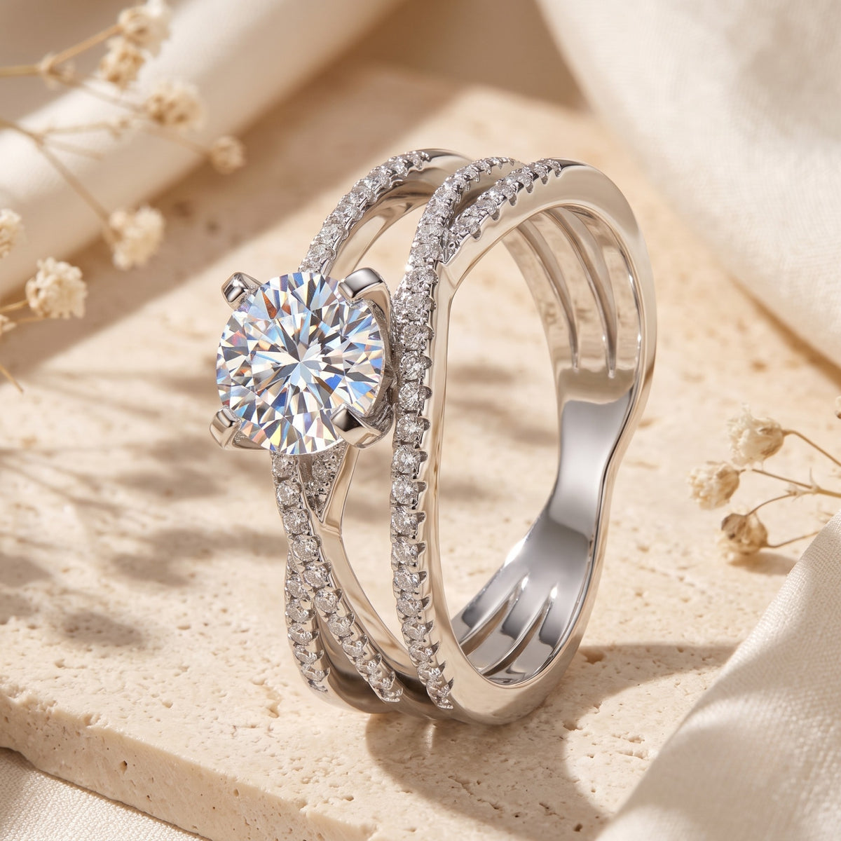 Close-up of silver criss-cross ring showing pavé-set bands and round brilliant center stone.