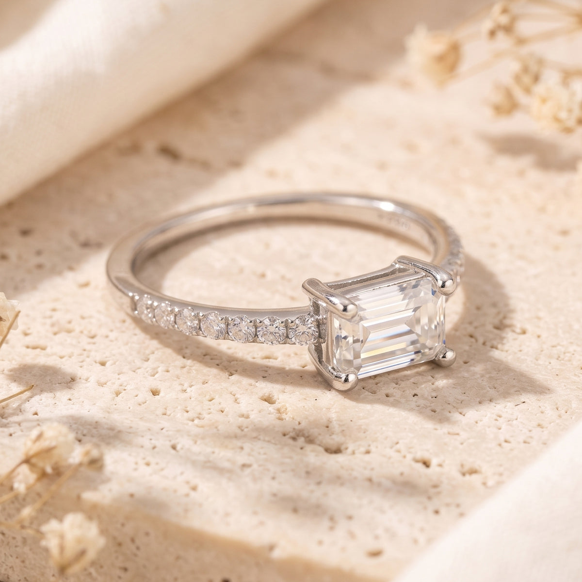 Side view of the silver Sarielle East-West ring showing the horizontal emerald-cut setting and pavé band.