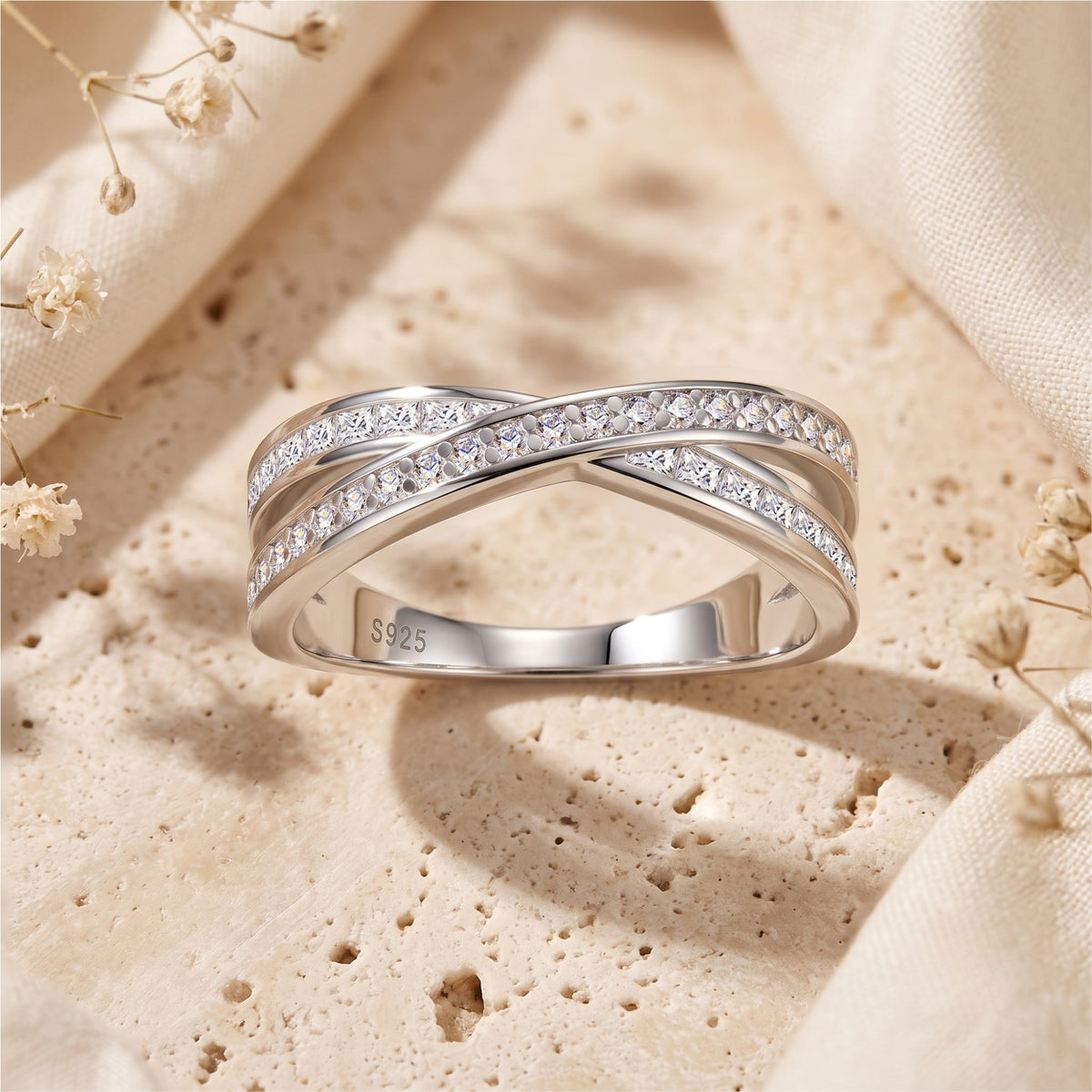 Front view of the silver crossover ring showing the S925 hallmark and paved round stones.